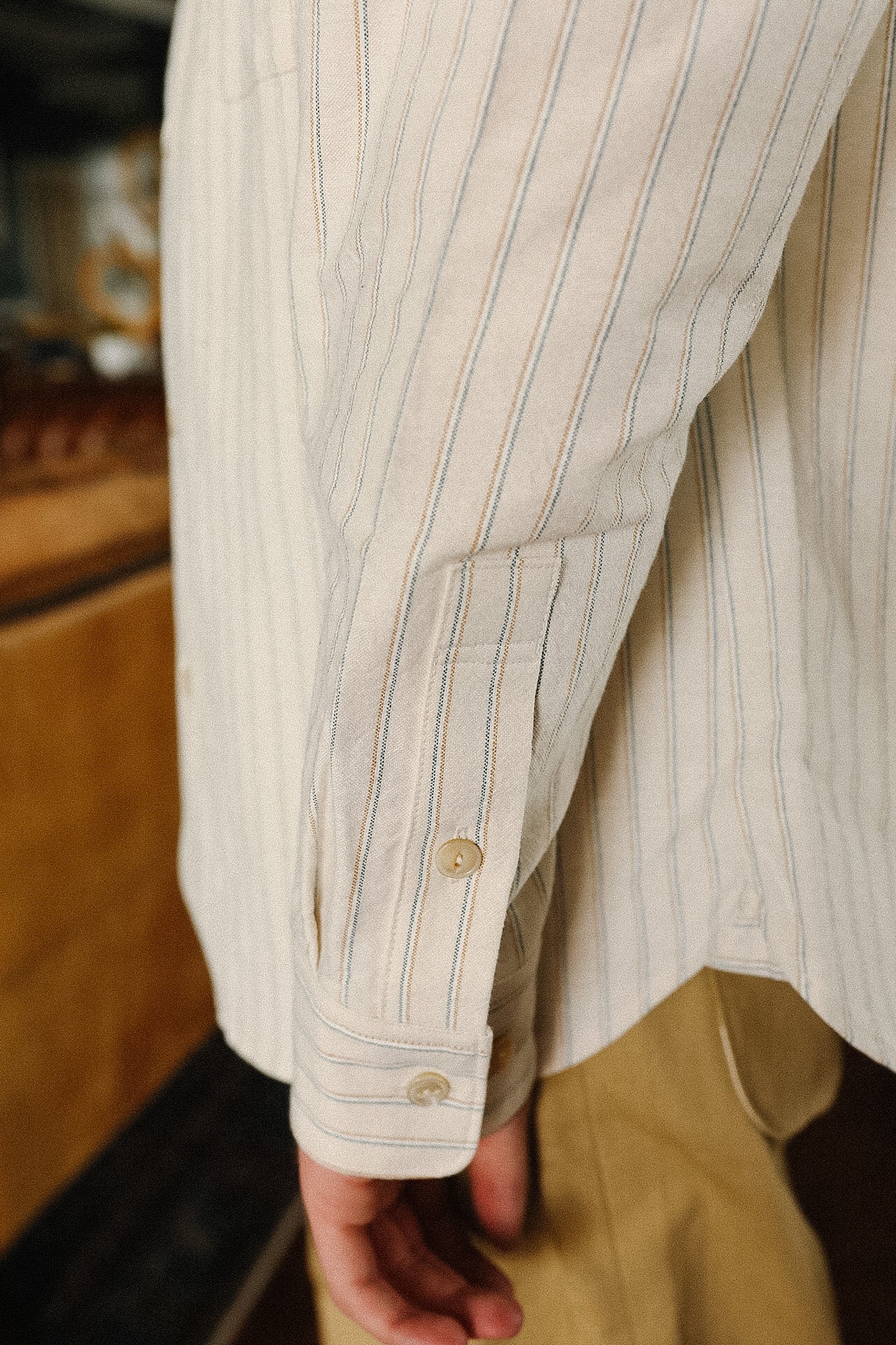 Close-up of a person wearing a striped shirt with a blurred background