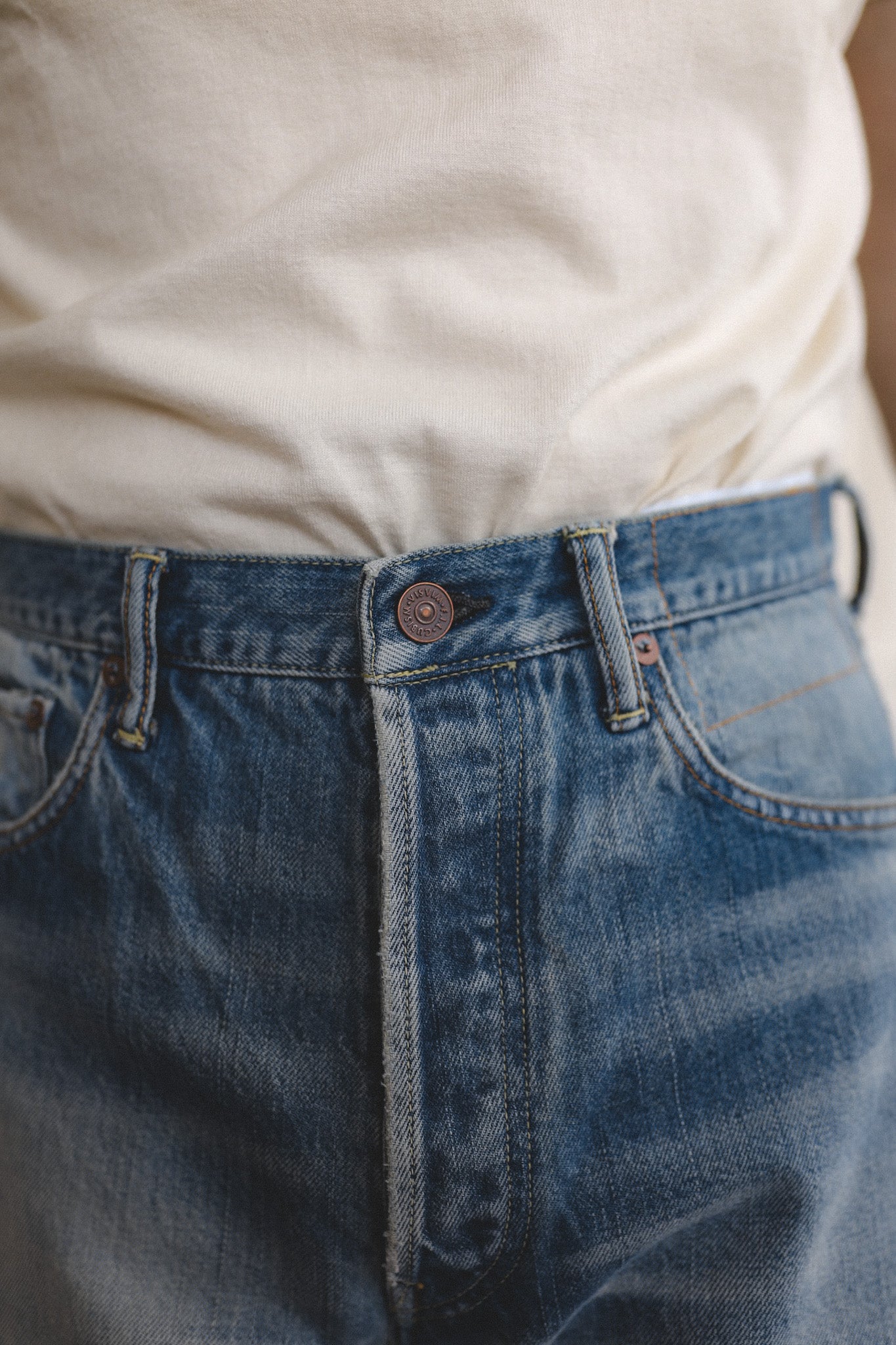 Close-up of blue jeans with a white shirt underneath