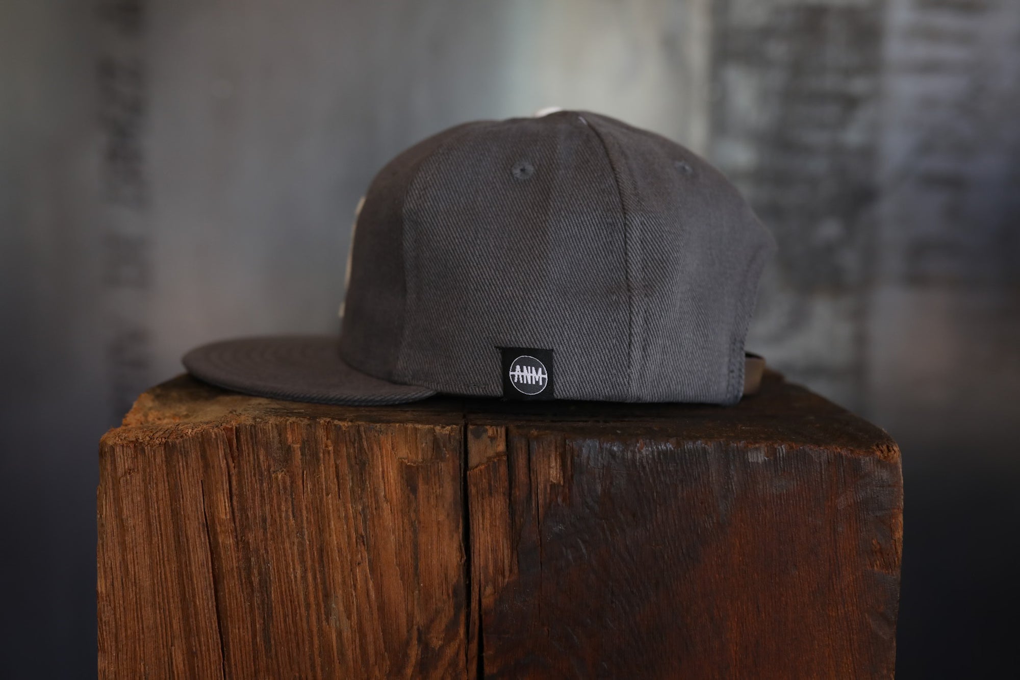 Gray cap with a logo on a wooden block against a blurred background