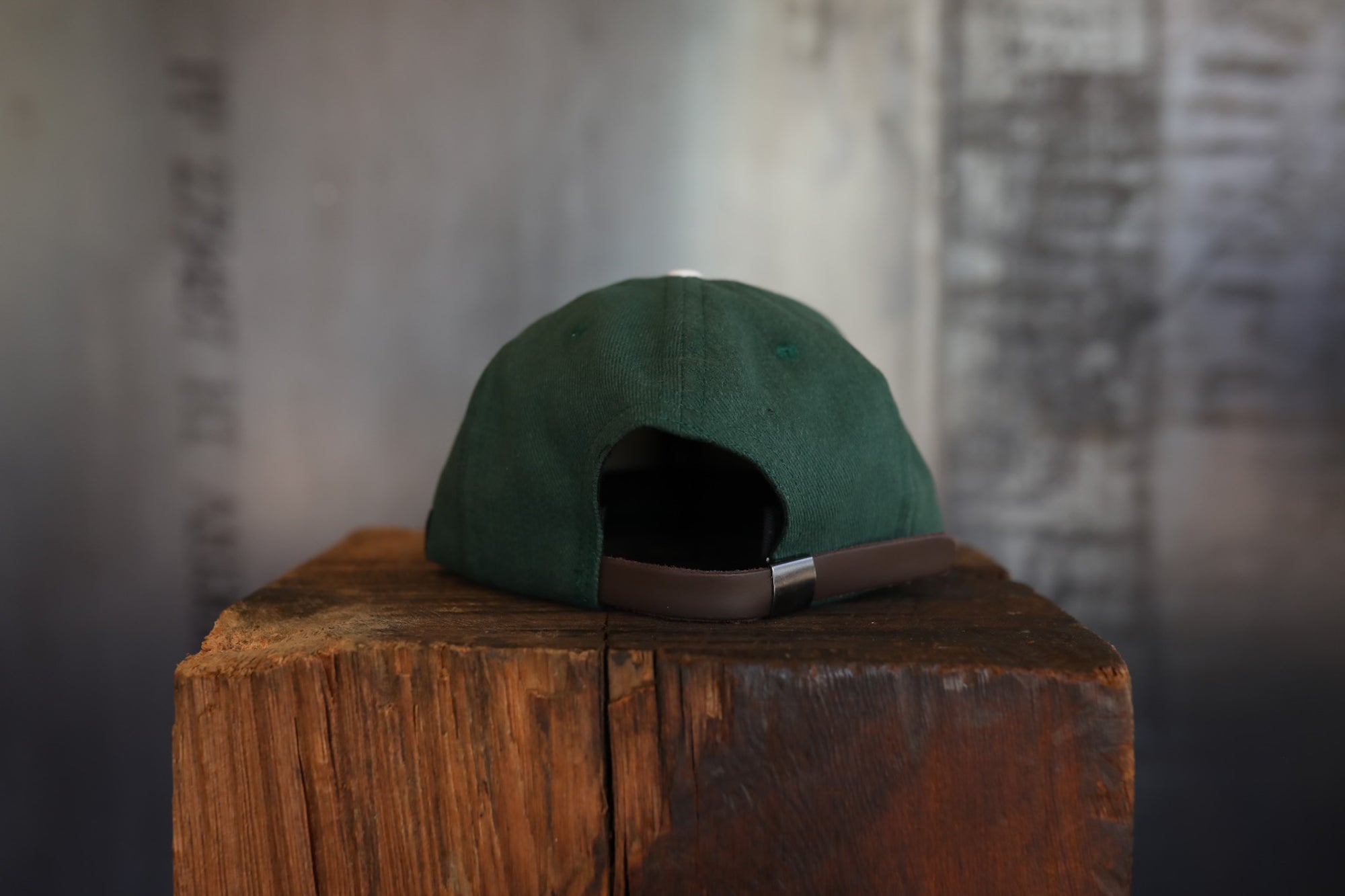 Green cap on a wooden block with a textured wall background