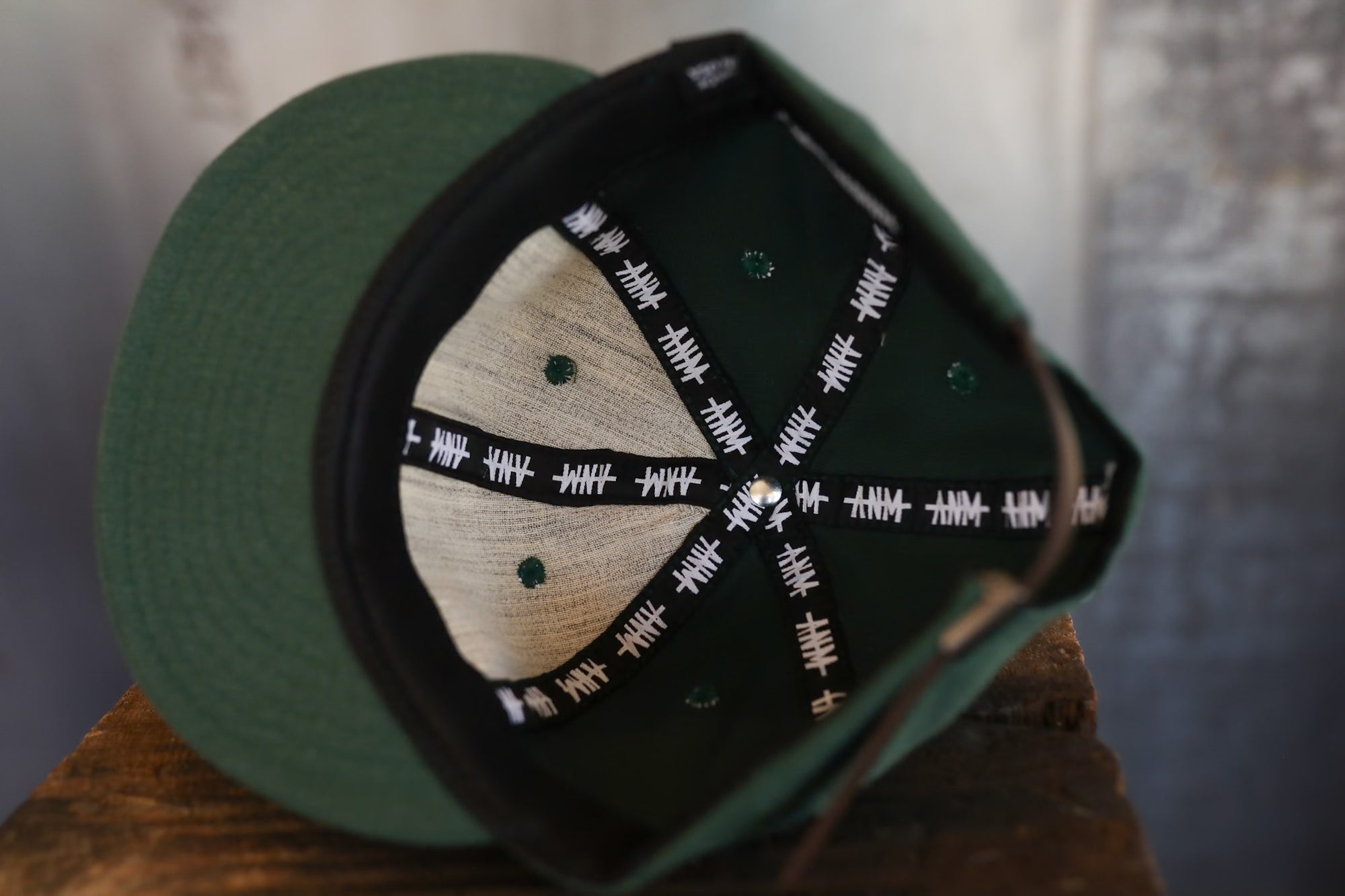 Green cap with a wooden emblem on a wooden surface