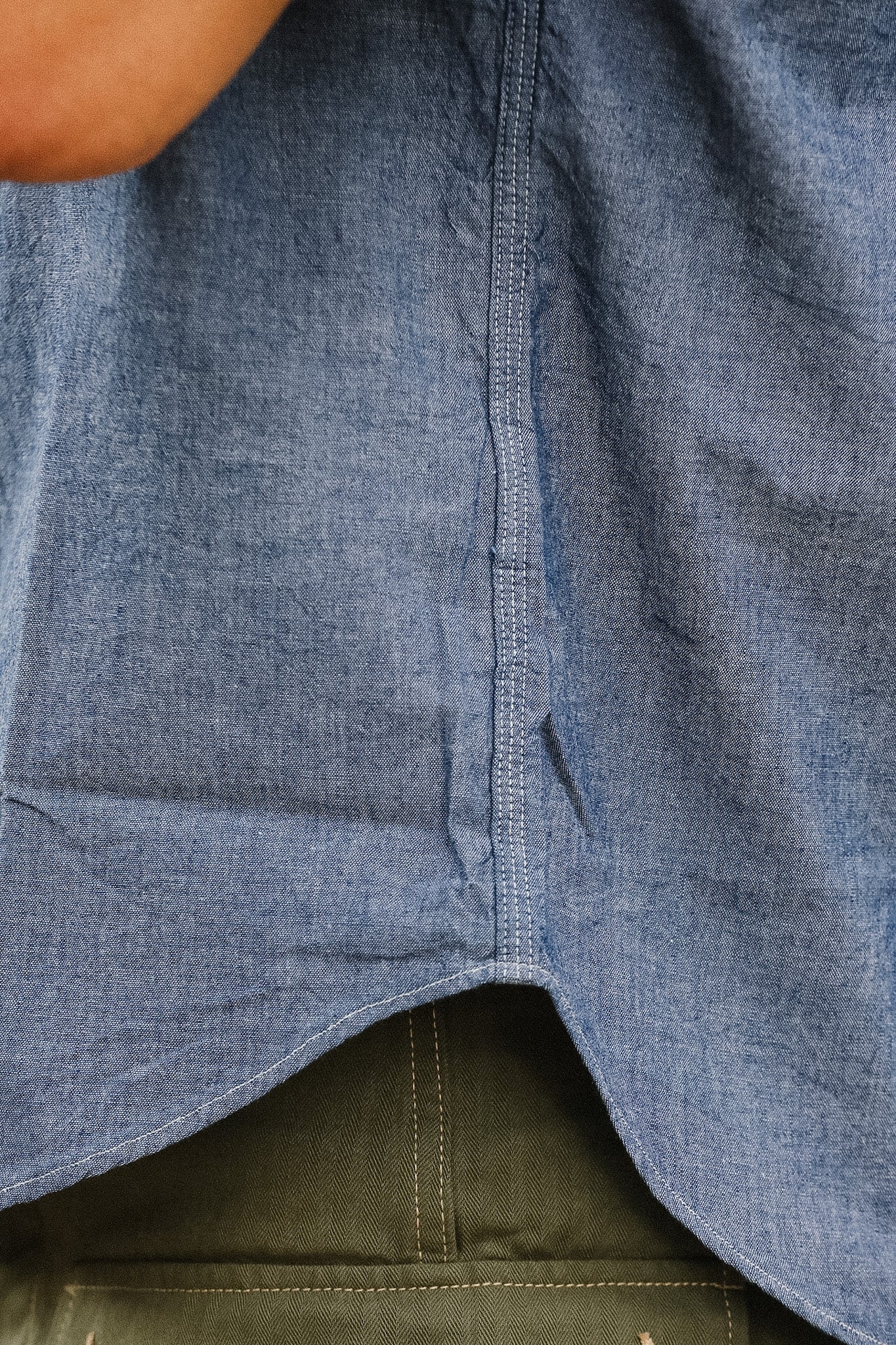 Close-up of a blue denim shirt with a green fabric underneath