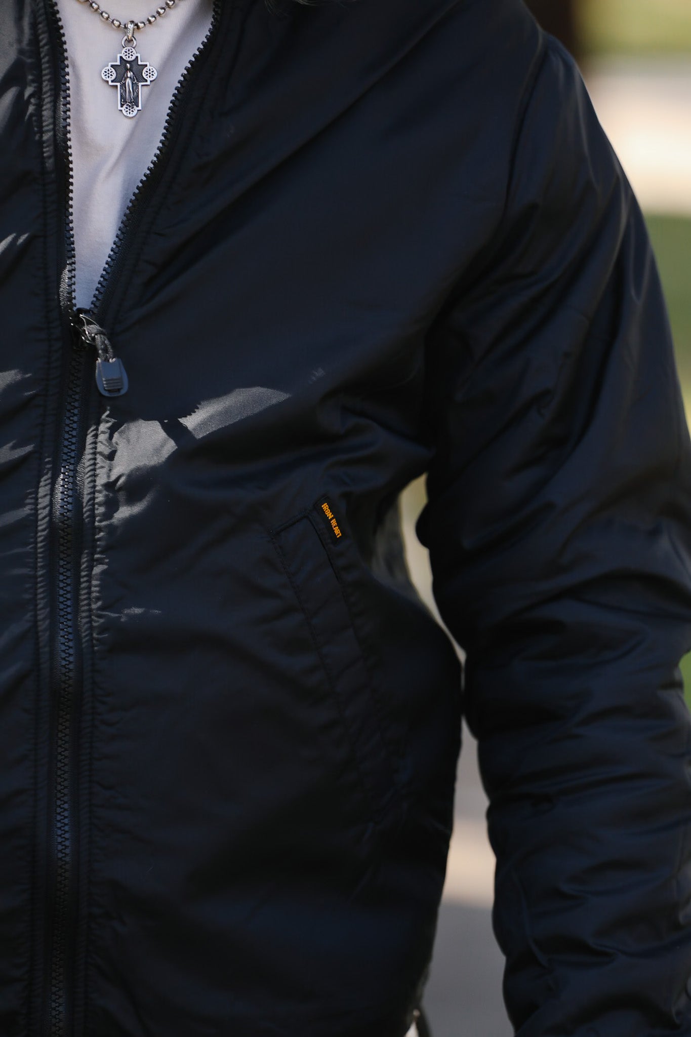 Close-up of a person wearing a dark blue jacket with a blurred background