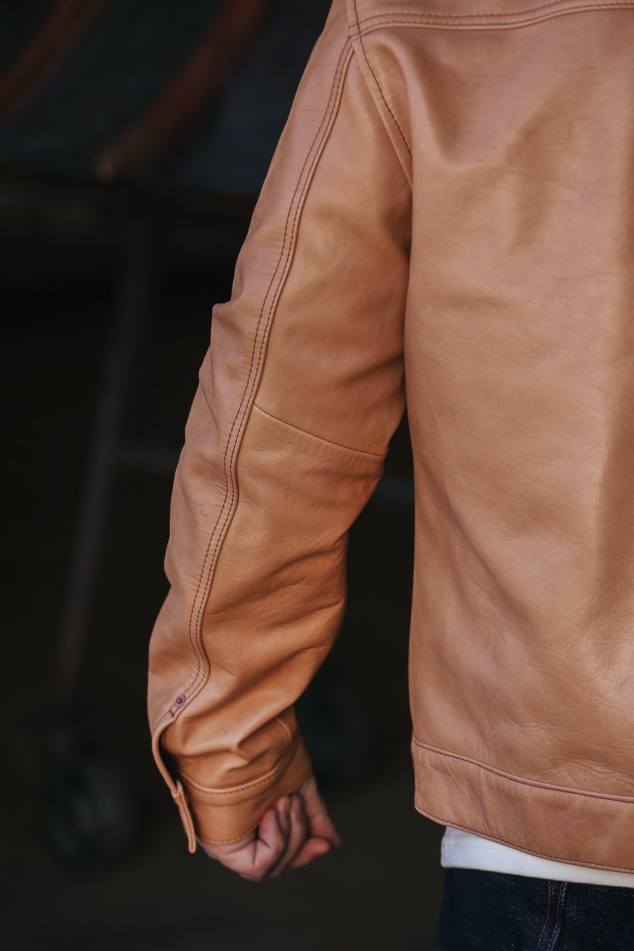 Man wearing leather jacket with white shirt . sleeve detail. 