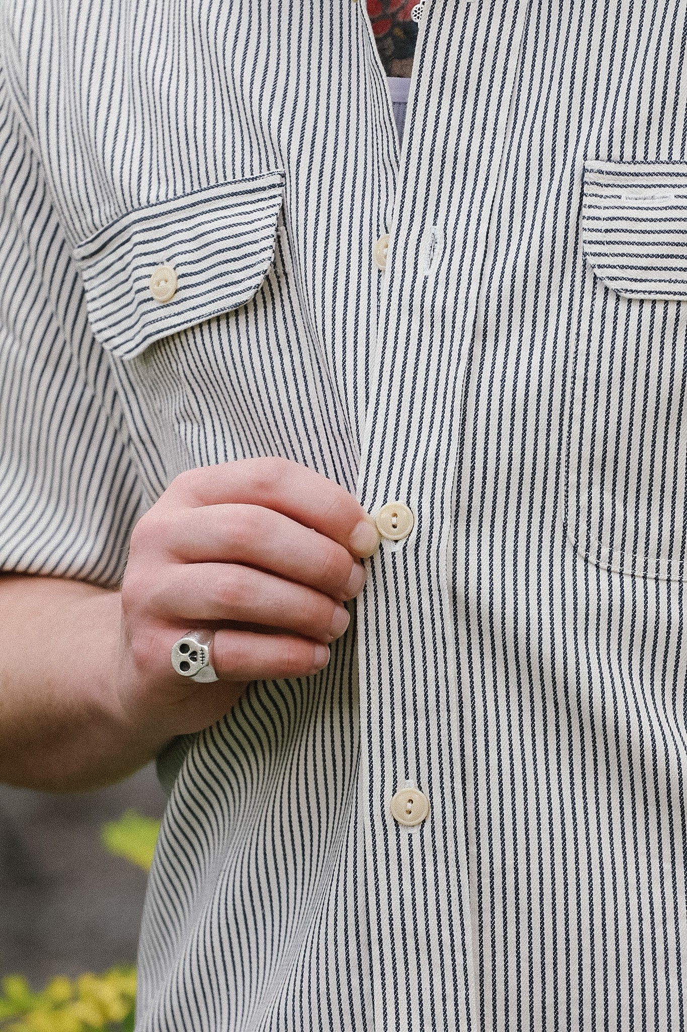 Close-up of a person wearing a striped shirt with a blurred background