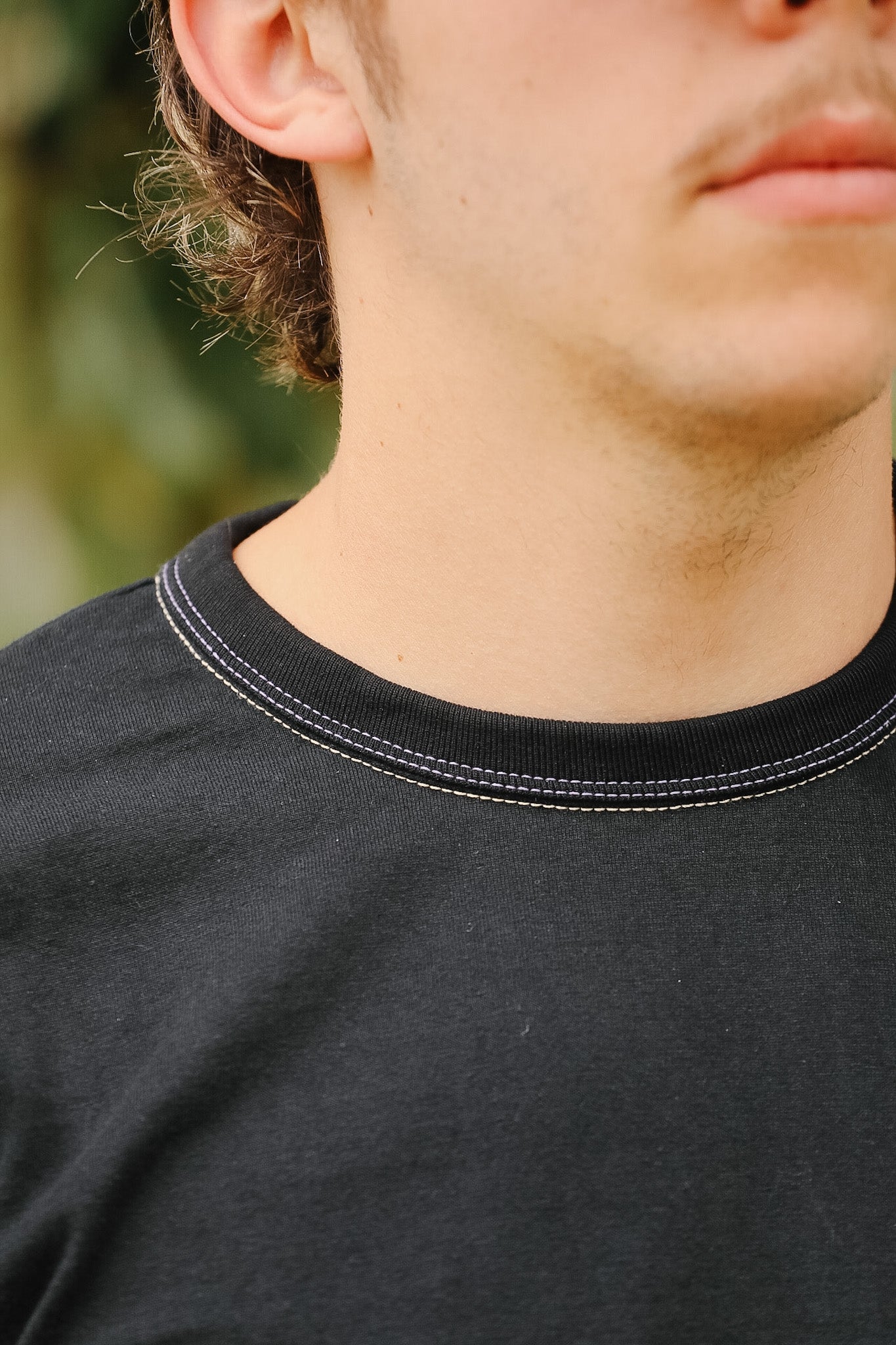 Close-up of a person wearing a black shirt with a blurred background