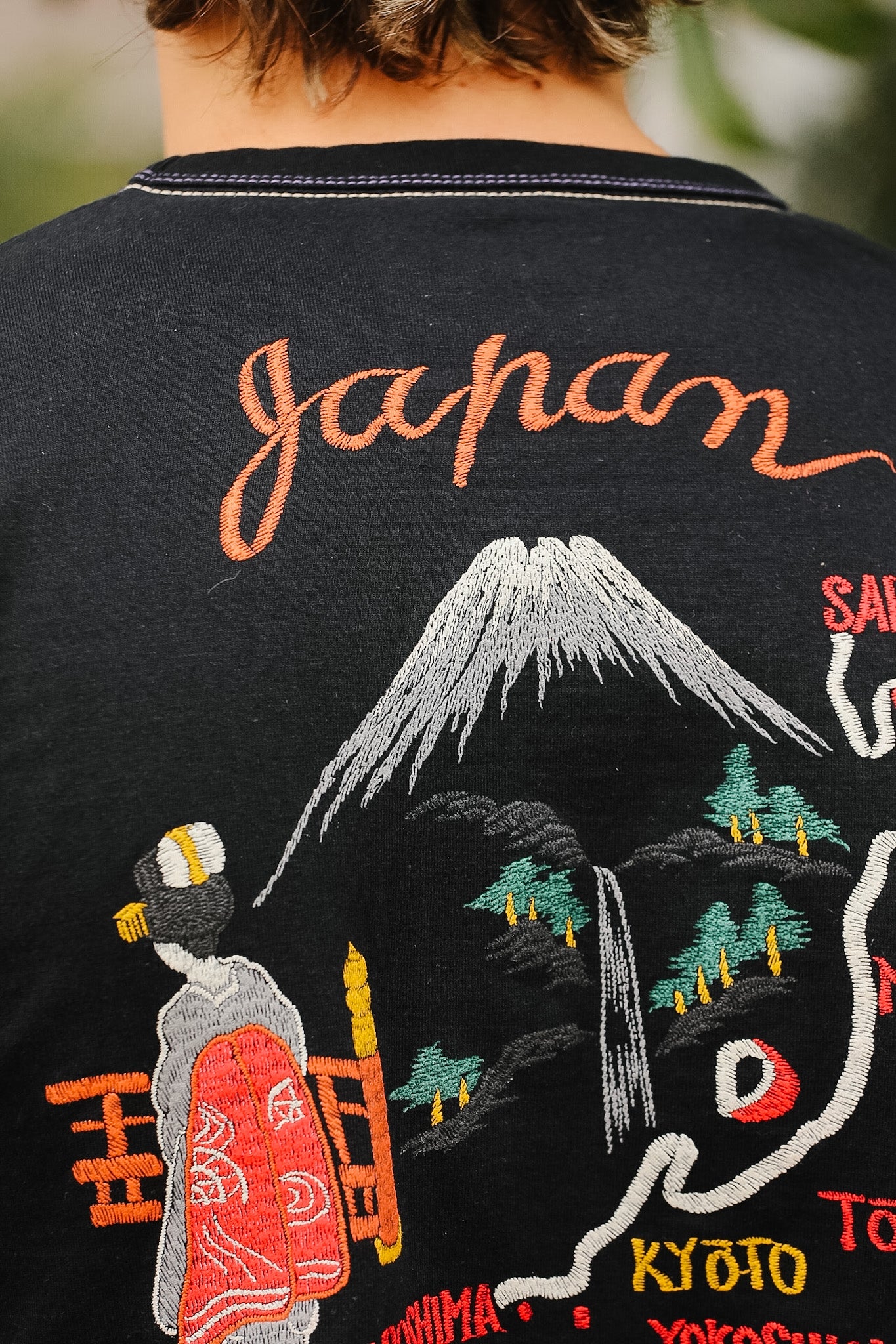 Black shirt with embroidered design of Mount Fuji and traditional Japanese elements.