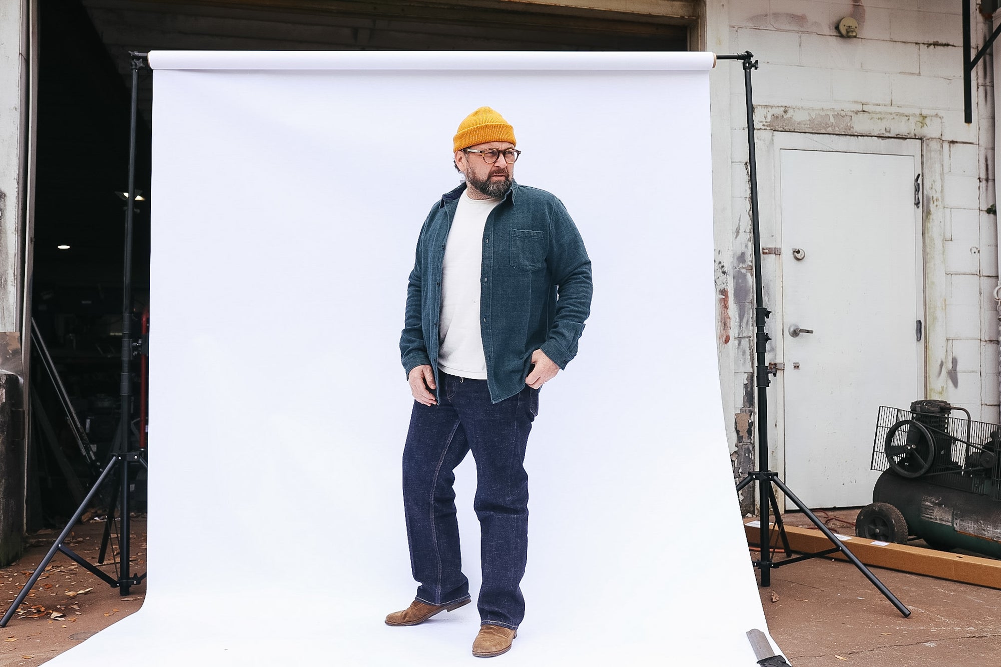 Man standing in front of a white backdrop with studio equipment around