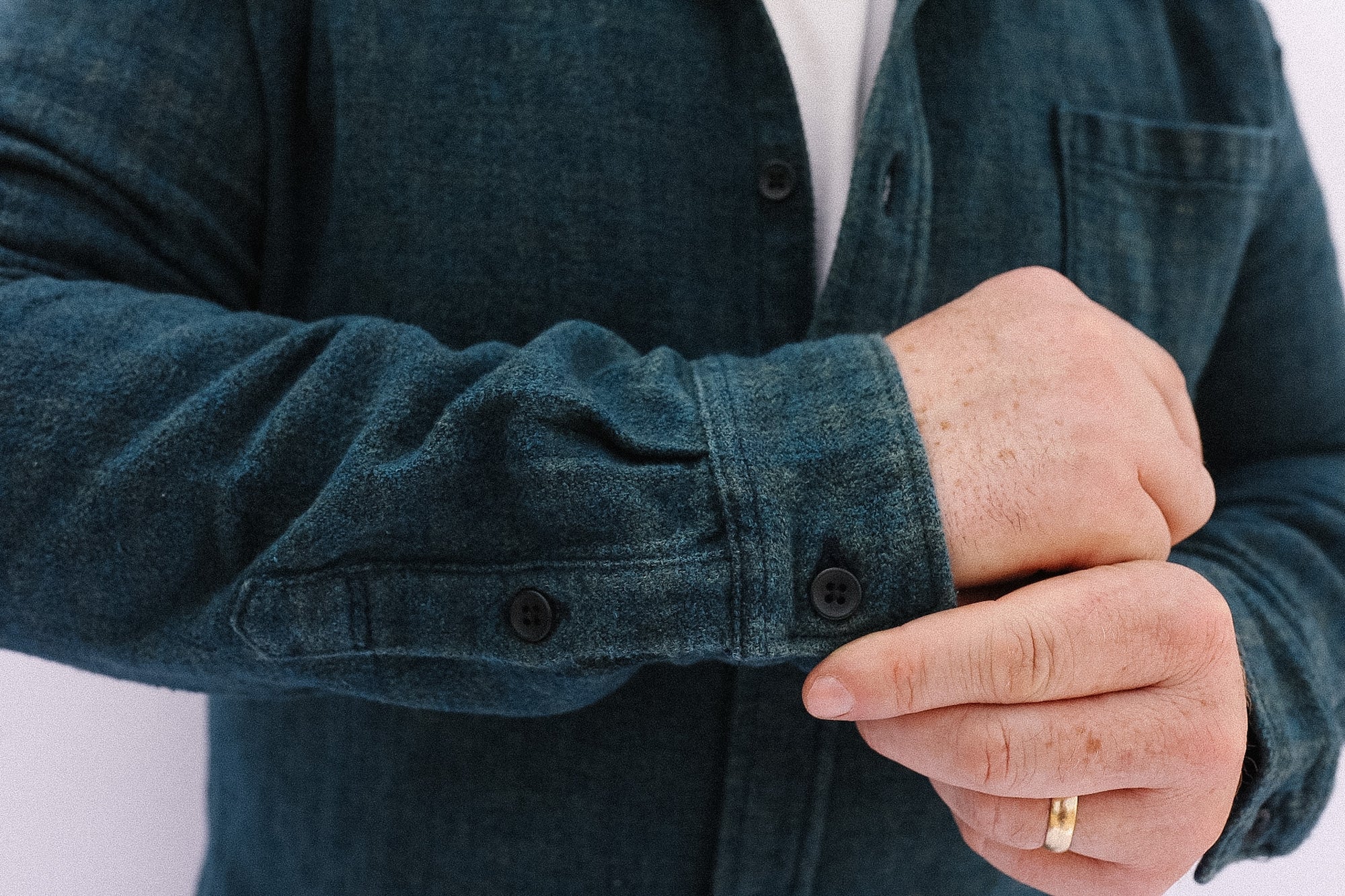 Person wearing a dark denim jacket with a white background