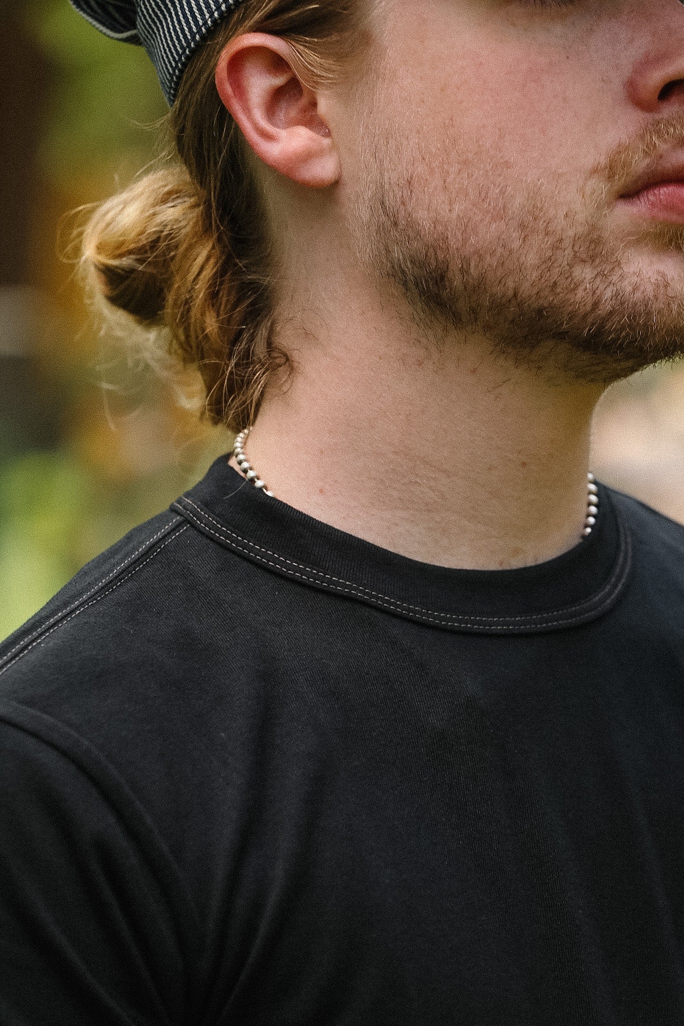 Close-up of a person wearing a black shirt with a blurred background