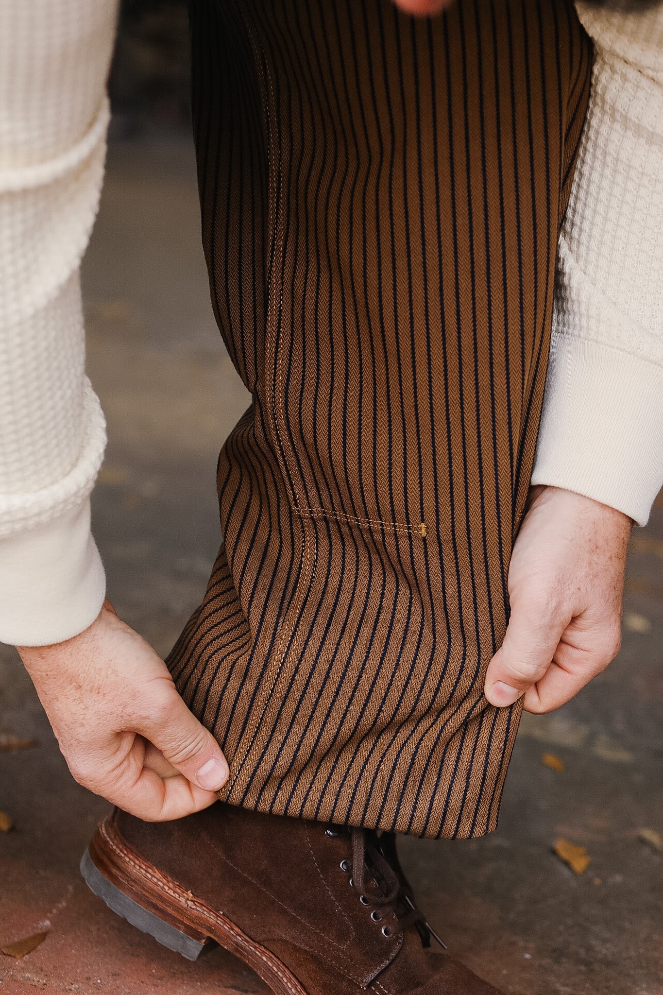 Brown pinstripe apron worn by a person with a blurred background