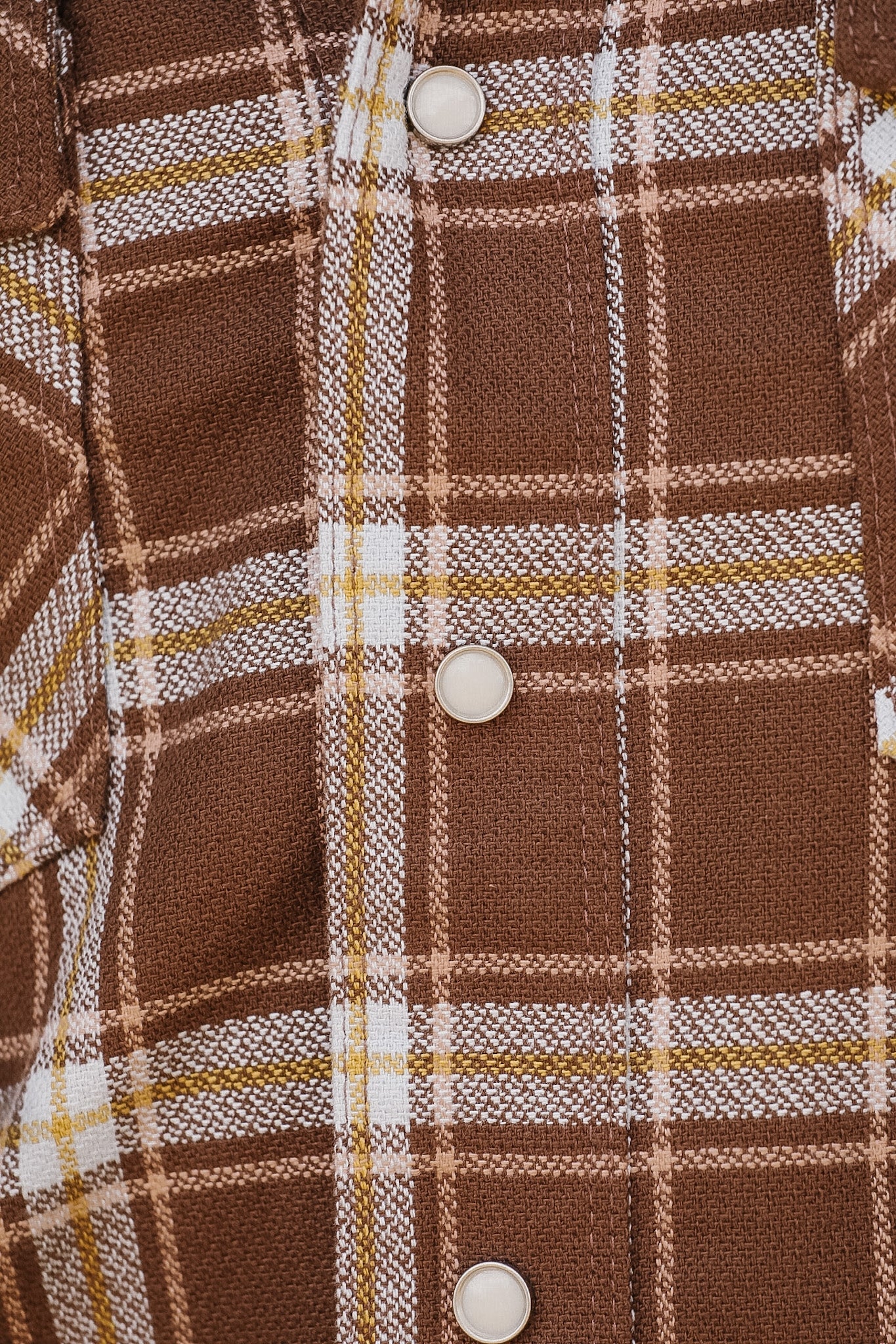 Close-up of a brown plaid shirt with buttons