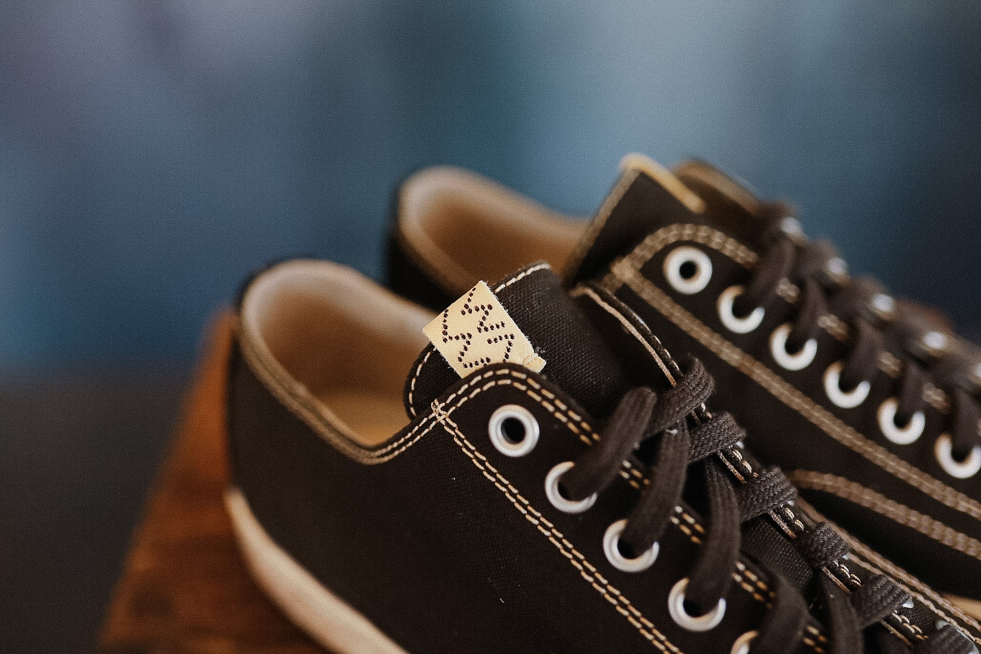 Close-up of brown sneakers with white laces on a blurred background
