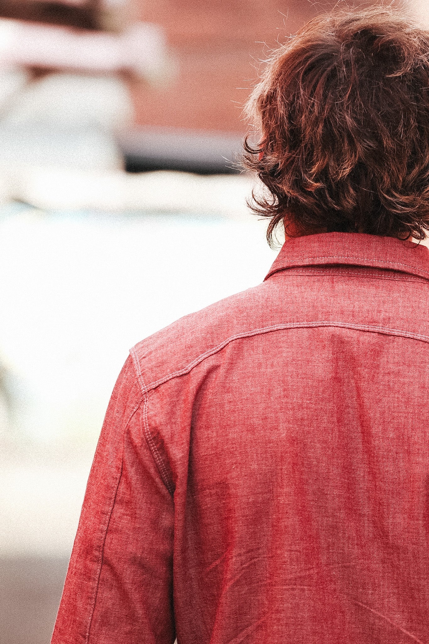Person wearing a red shirt with a blurred background