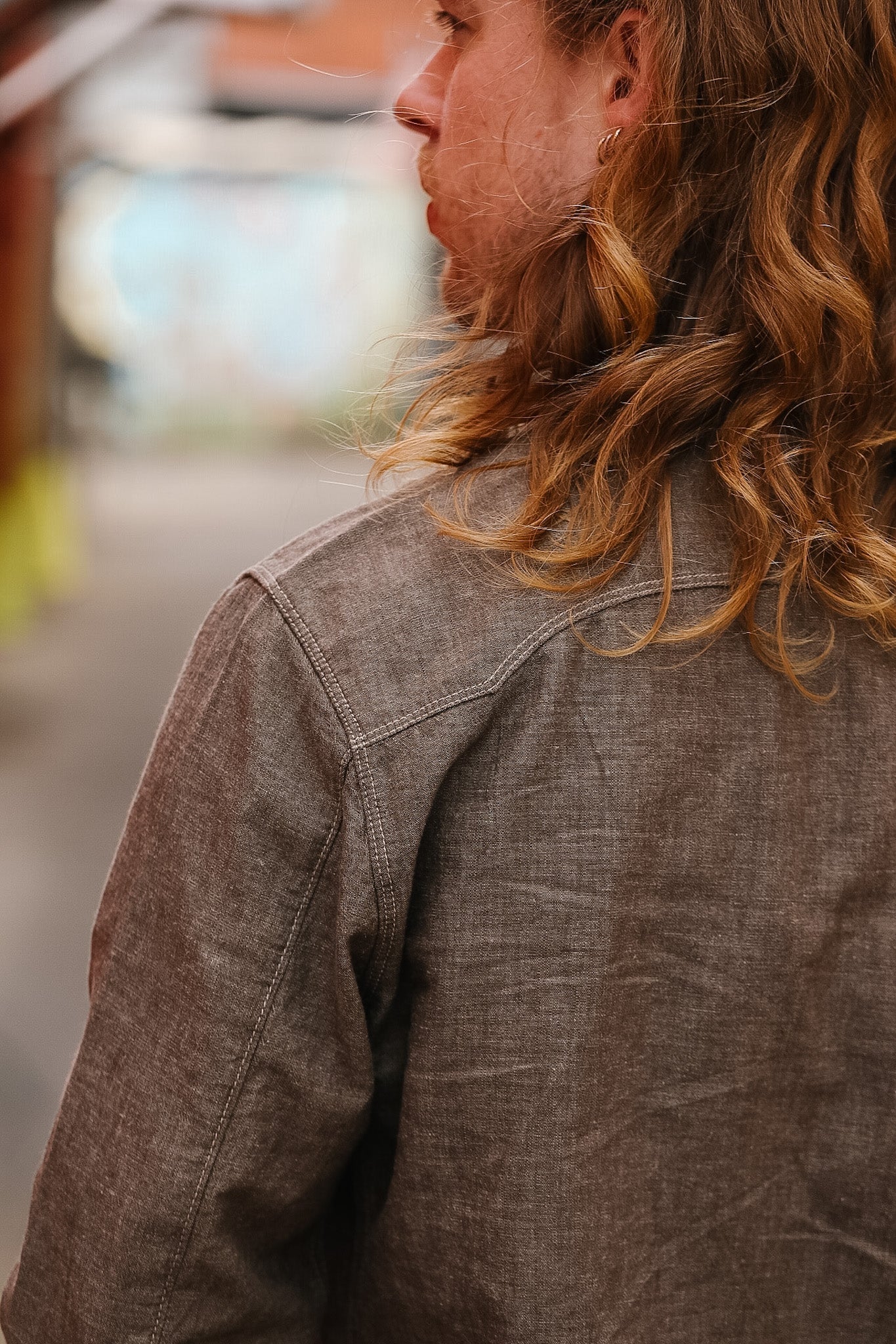 Person wearing a brown jacket with a blurred background