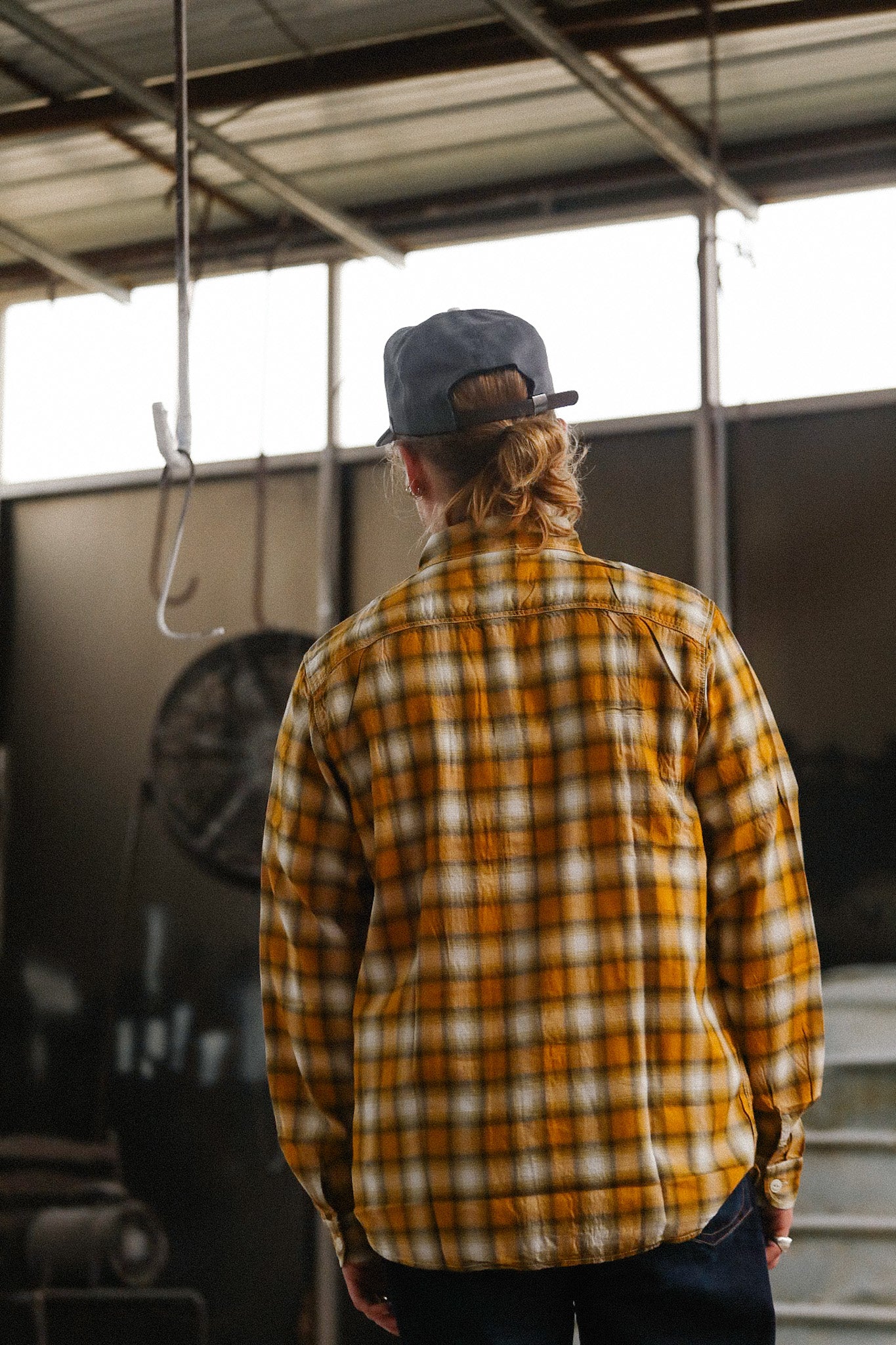 Close-up of a person wearing a plaid shirt with a blurred background