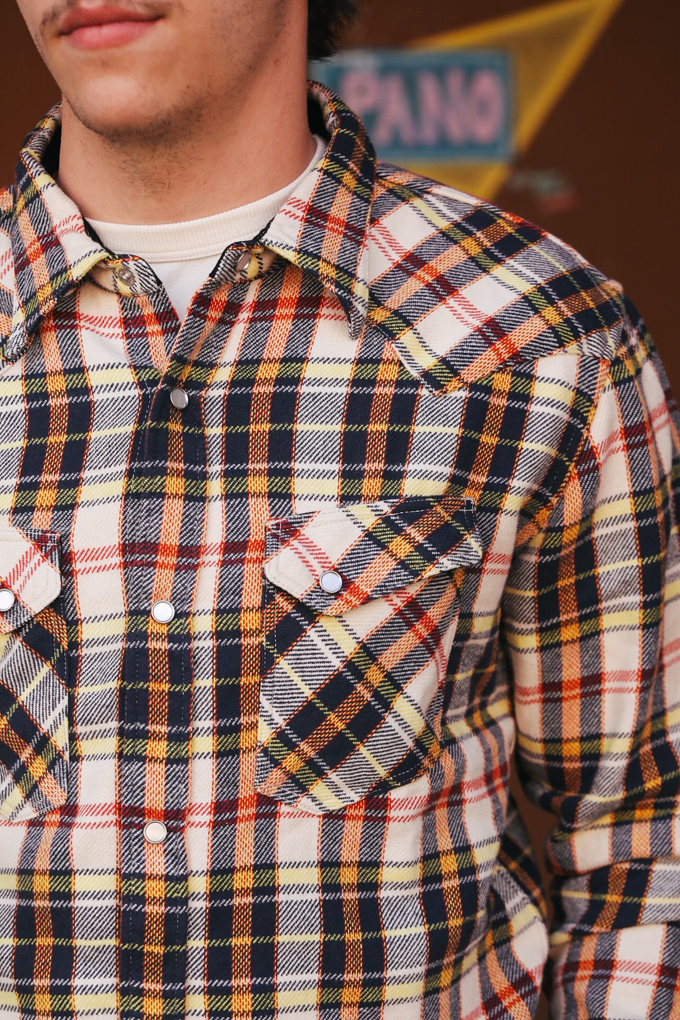 Plaid shirt worn by a person with a blurred background