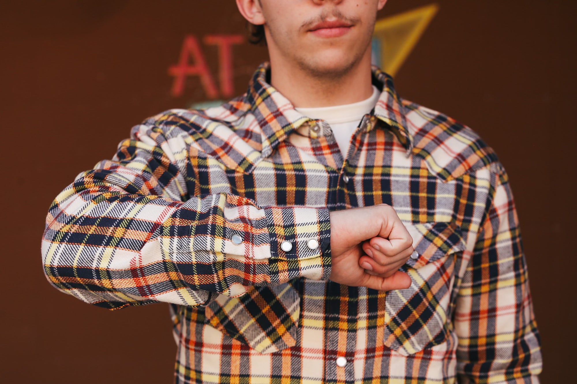 Person wearing a plaid shirt with a blurred background