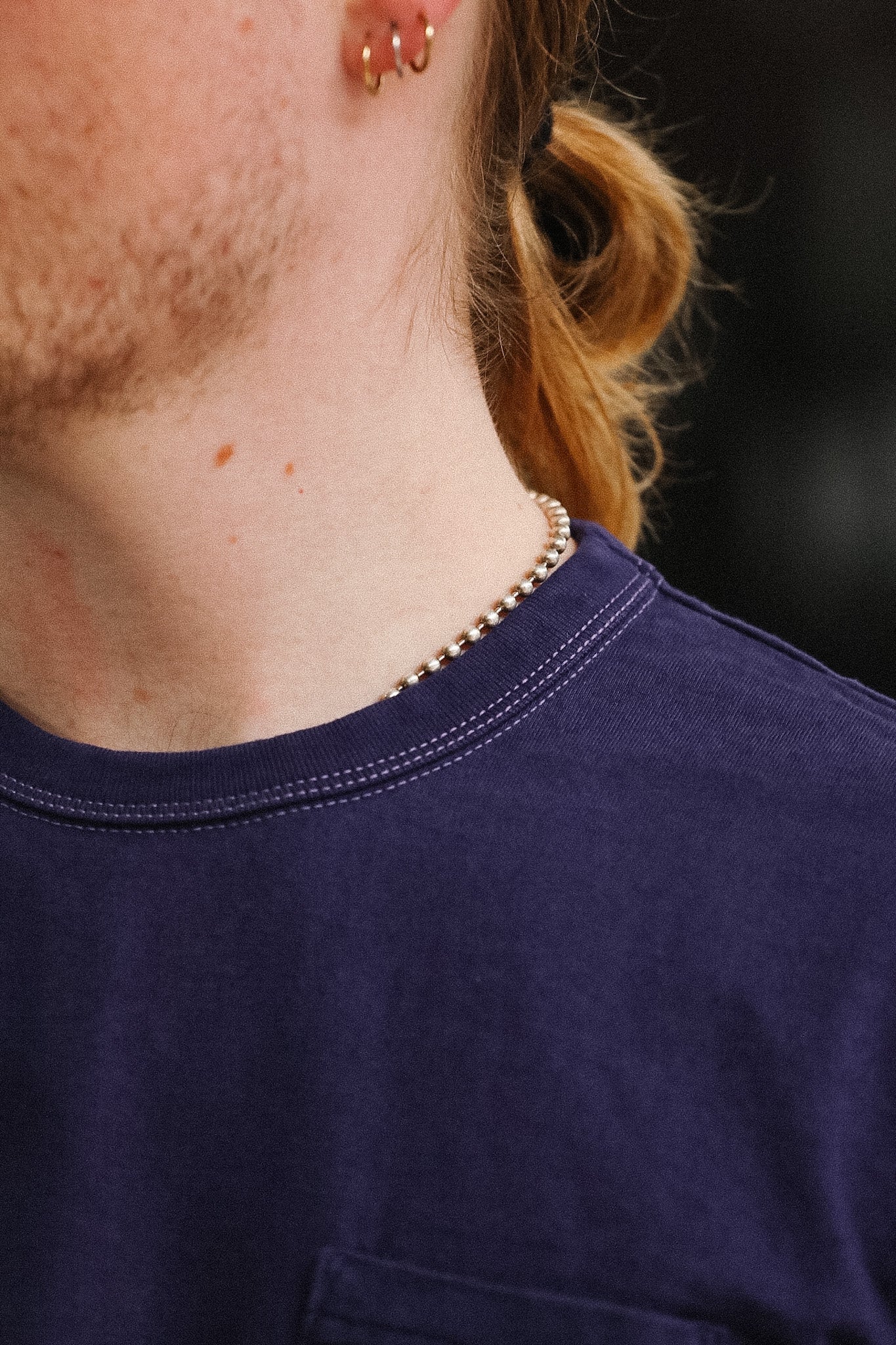 man wearing purple t-shirt on blurred background 