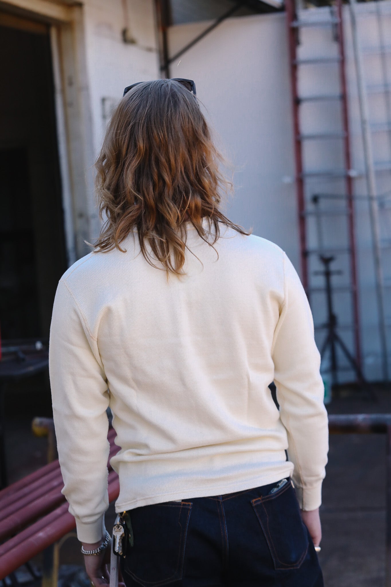Person wearing a cream-colored sweater with a blurred background