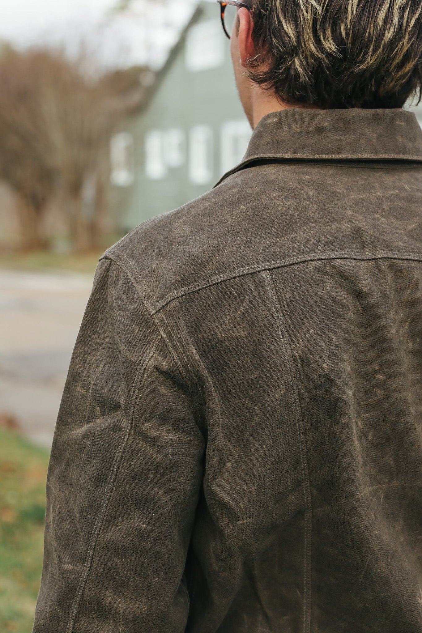 Person wearing a brown leather jacket with a blurred background