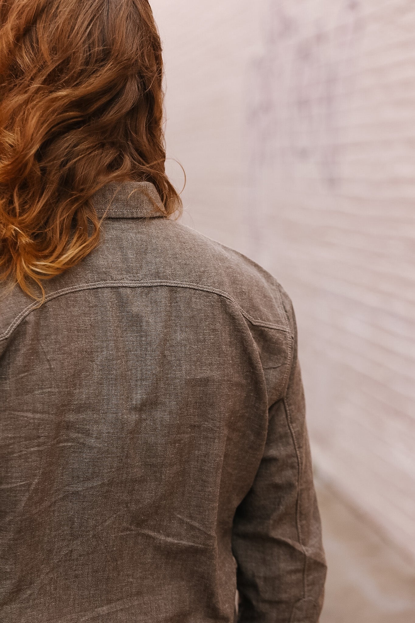Person wearing a brown shirt with a neutral background