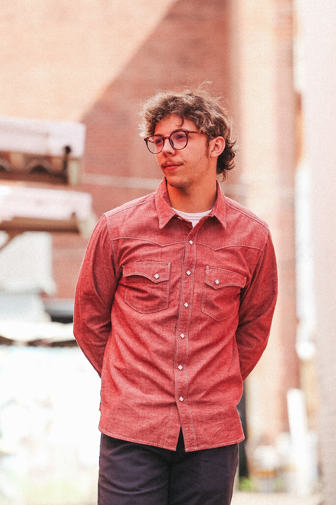 Man wearing a red shirt and glasses outdoors