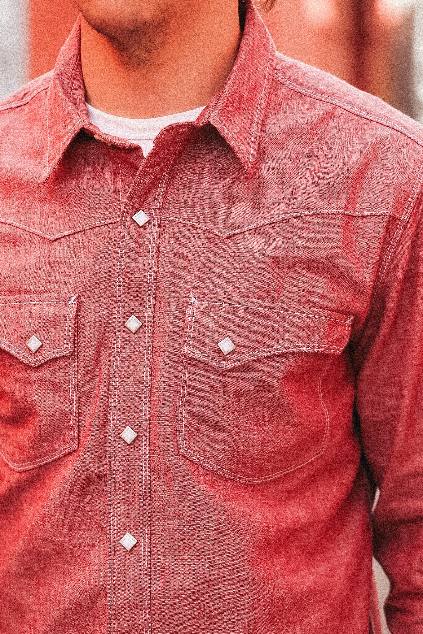 Close-up of a red denim shirt with white buttons