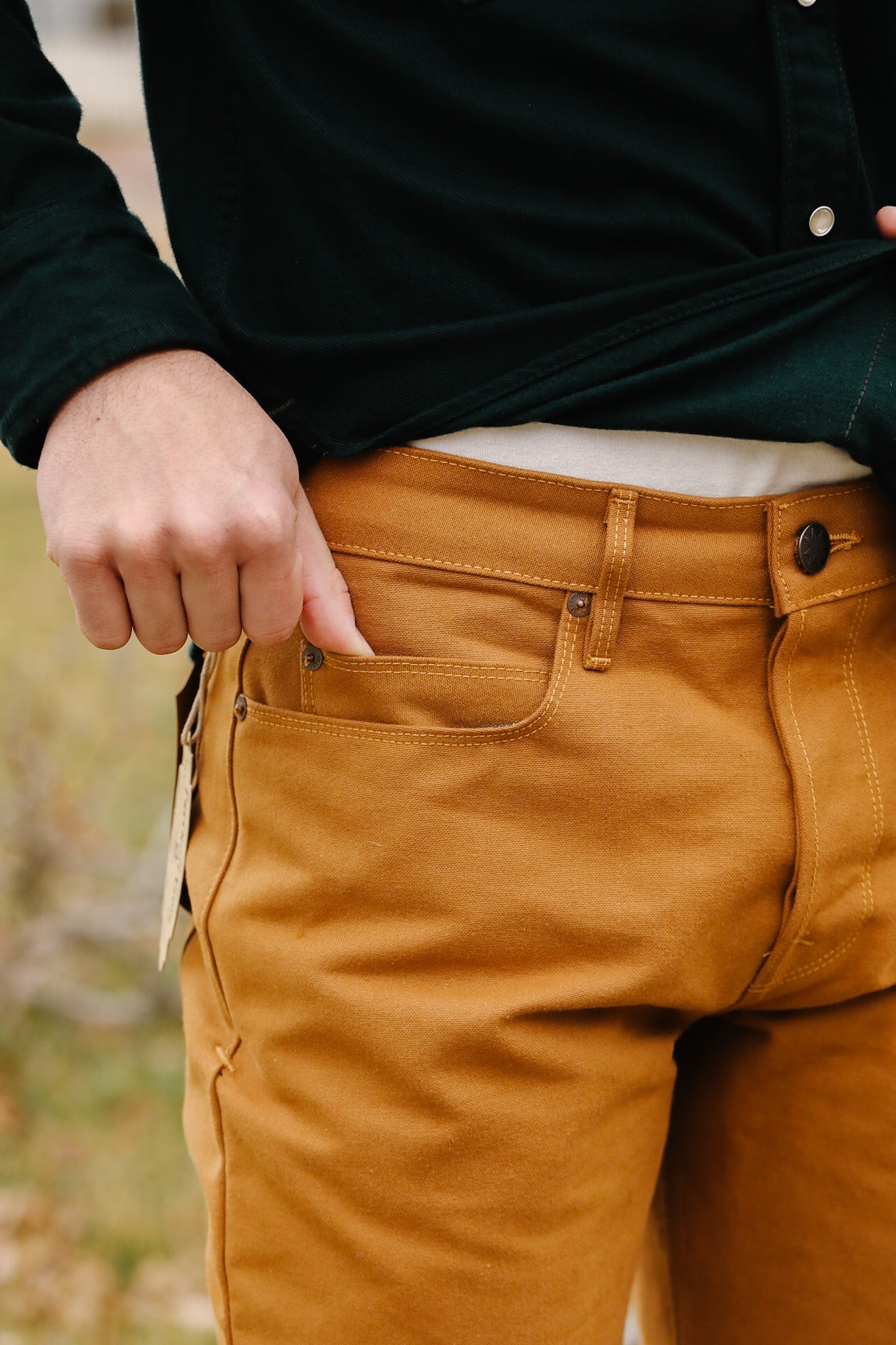 Person wearing mustard yellow pants with a blurred background