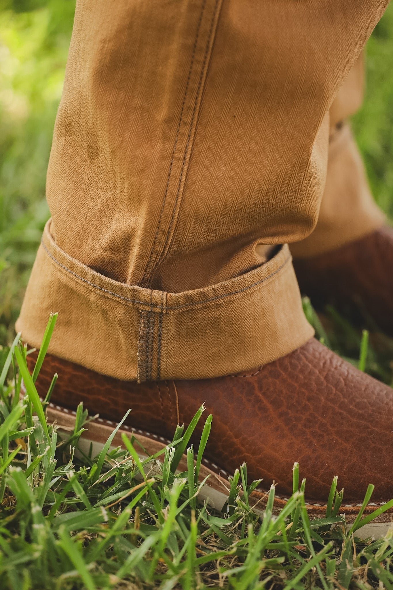 Brown shoes and pants on a grassy surface