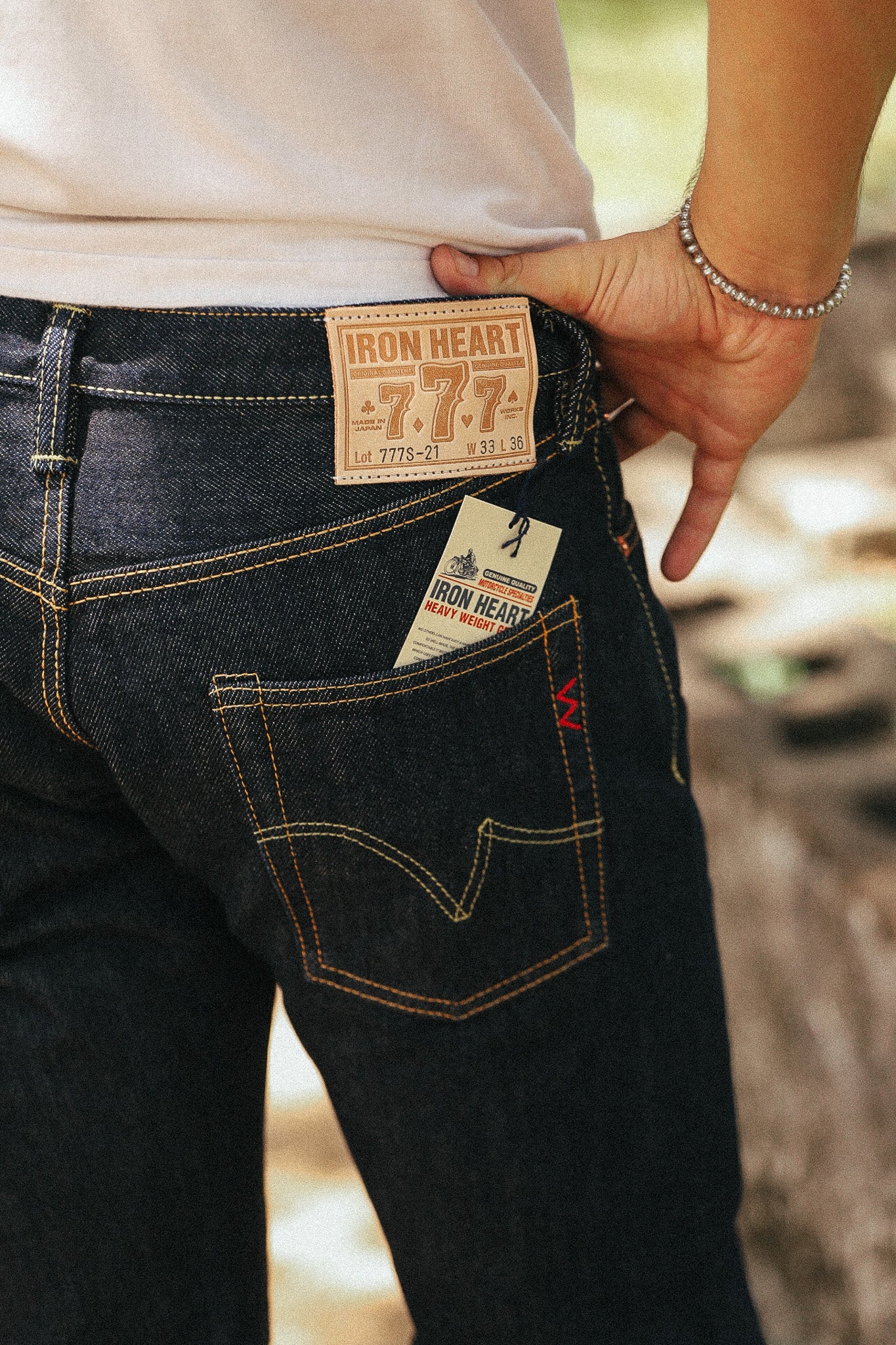 Close-up of a person wearing dark indigo jeans with visible Iron Heart 7.7.