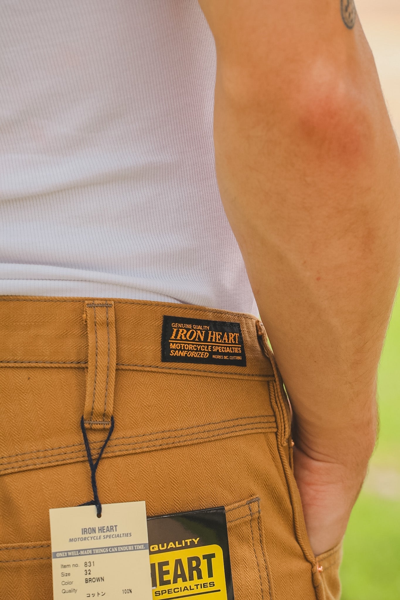 Brown pants with Iron Heart label and branding on a blurred background