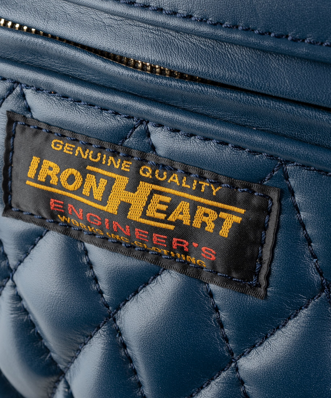 Close-up of a blue leather glove with an Iron Heart label.