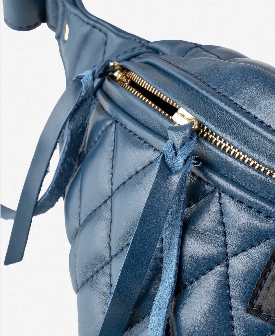 Blue quilted handbag with a gold zipper on a light gray background