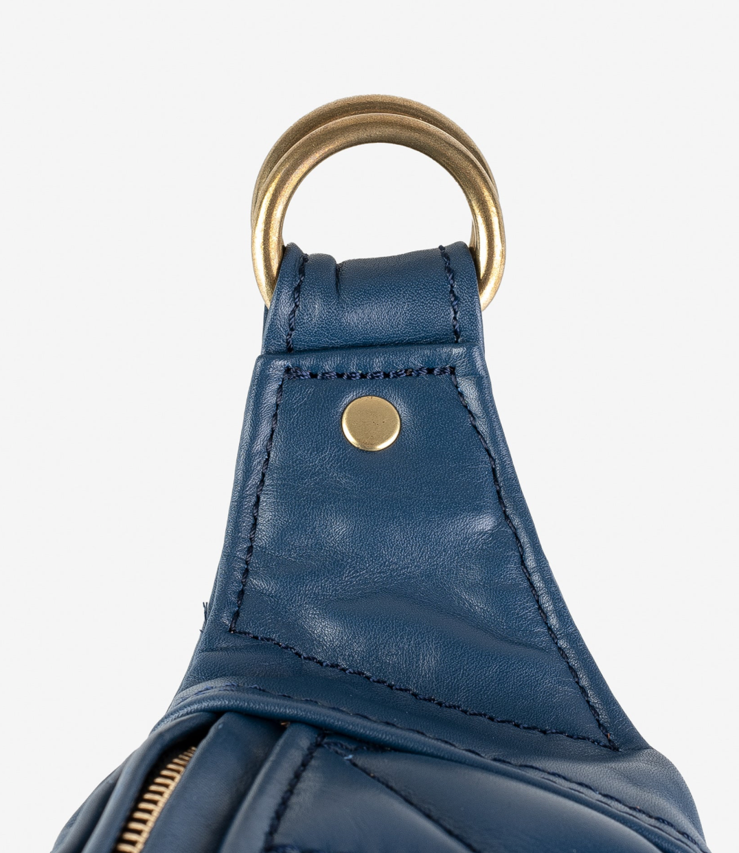 Close-up of a blue leather bag with gold hardware on a white background