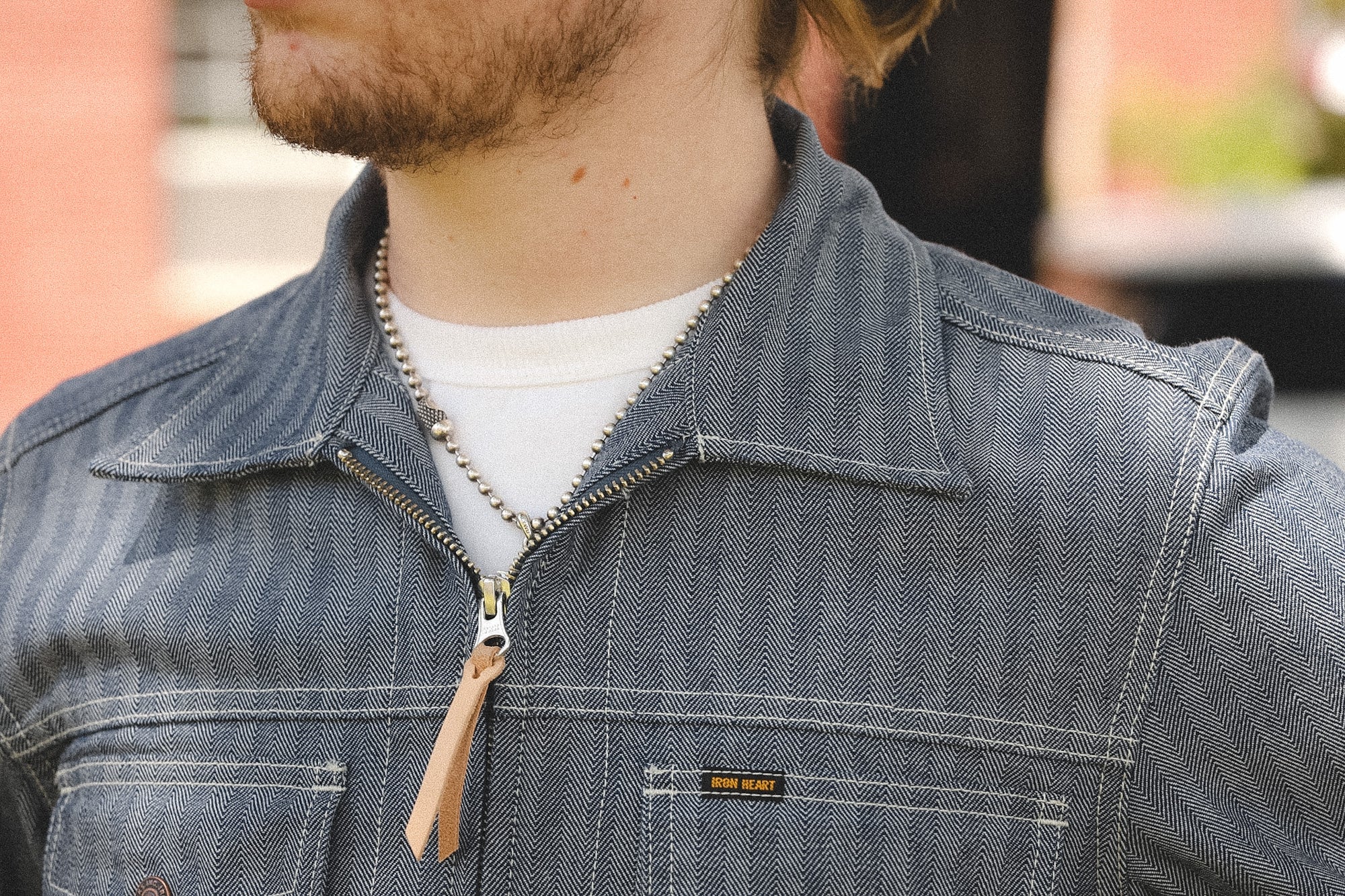 detail shot of a denim stripe jacket outdoors with a blurred background 