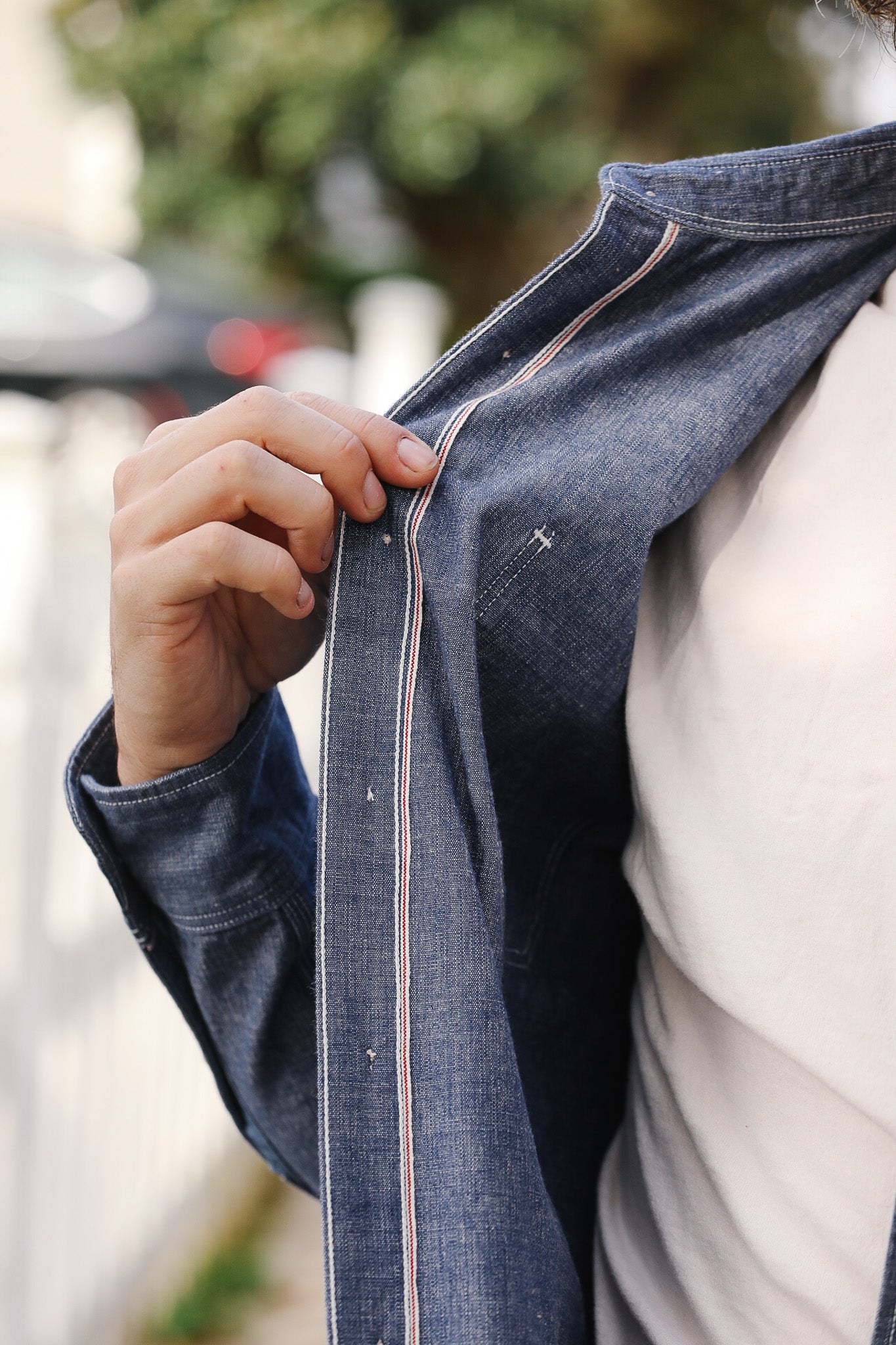 Person wearing a blue denim jacket with a blurred background