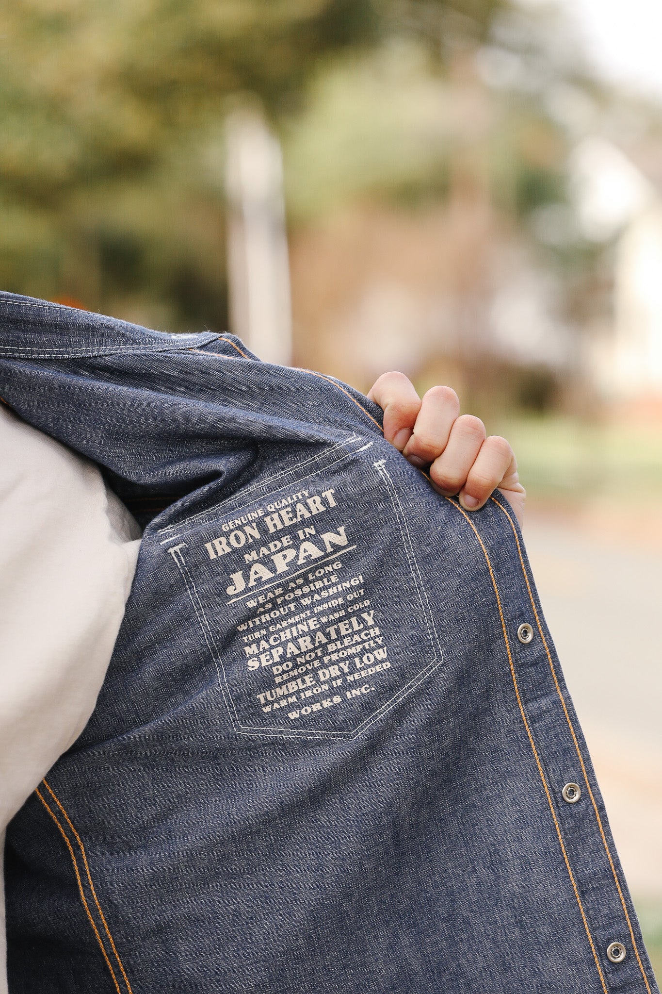 Denim jacket with text on a blurred outdoor background