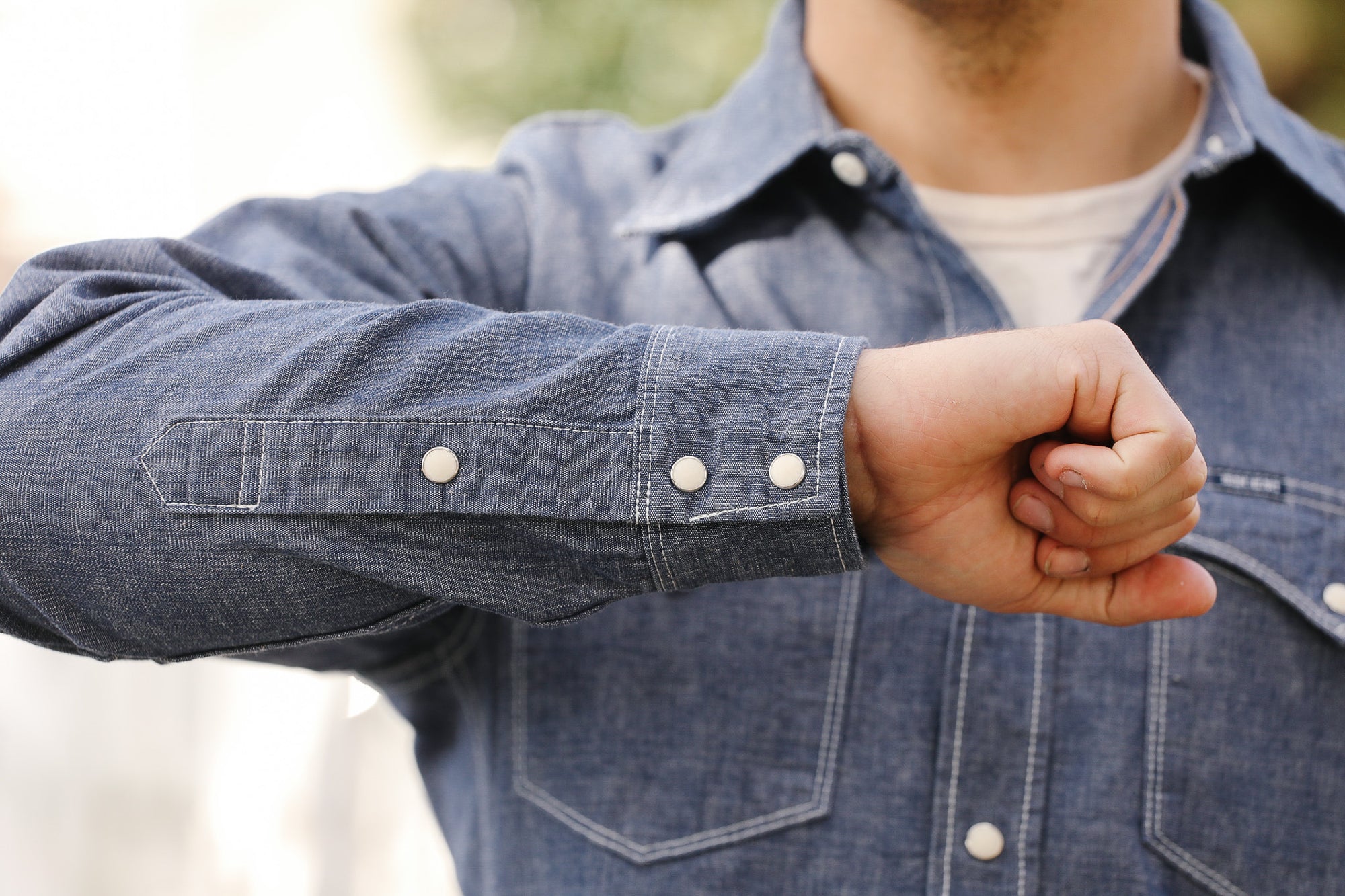 Person wearing a blue denim jacket with a blurred background