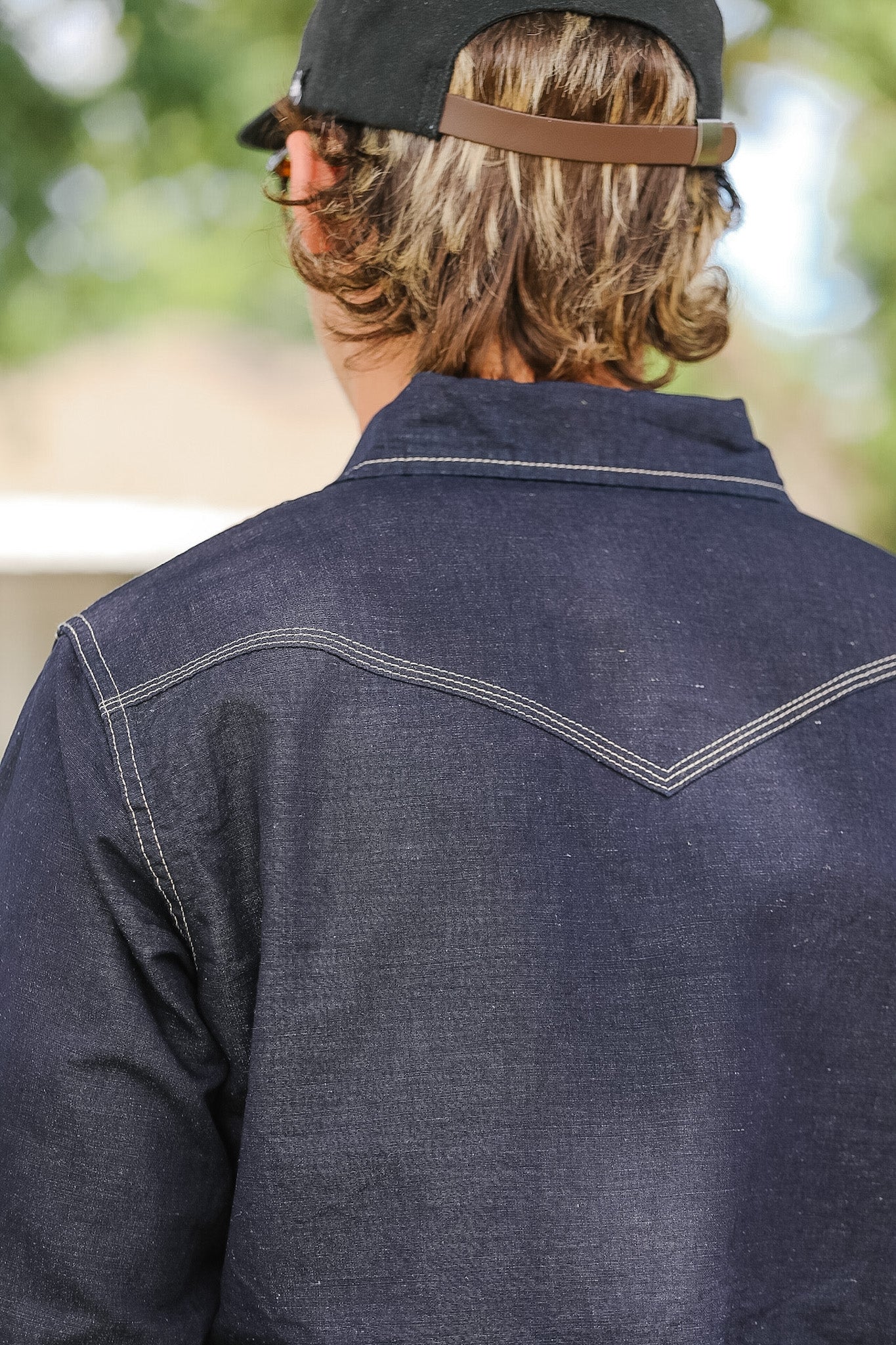 Person wearing a dark denim jacket with a blurred background