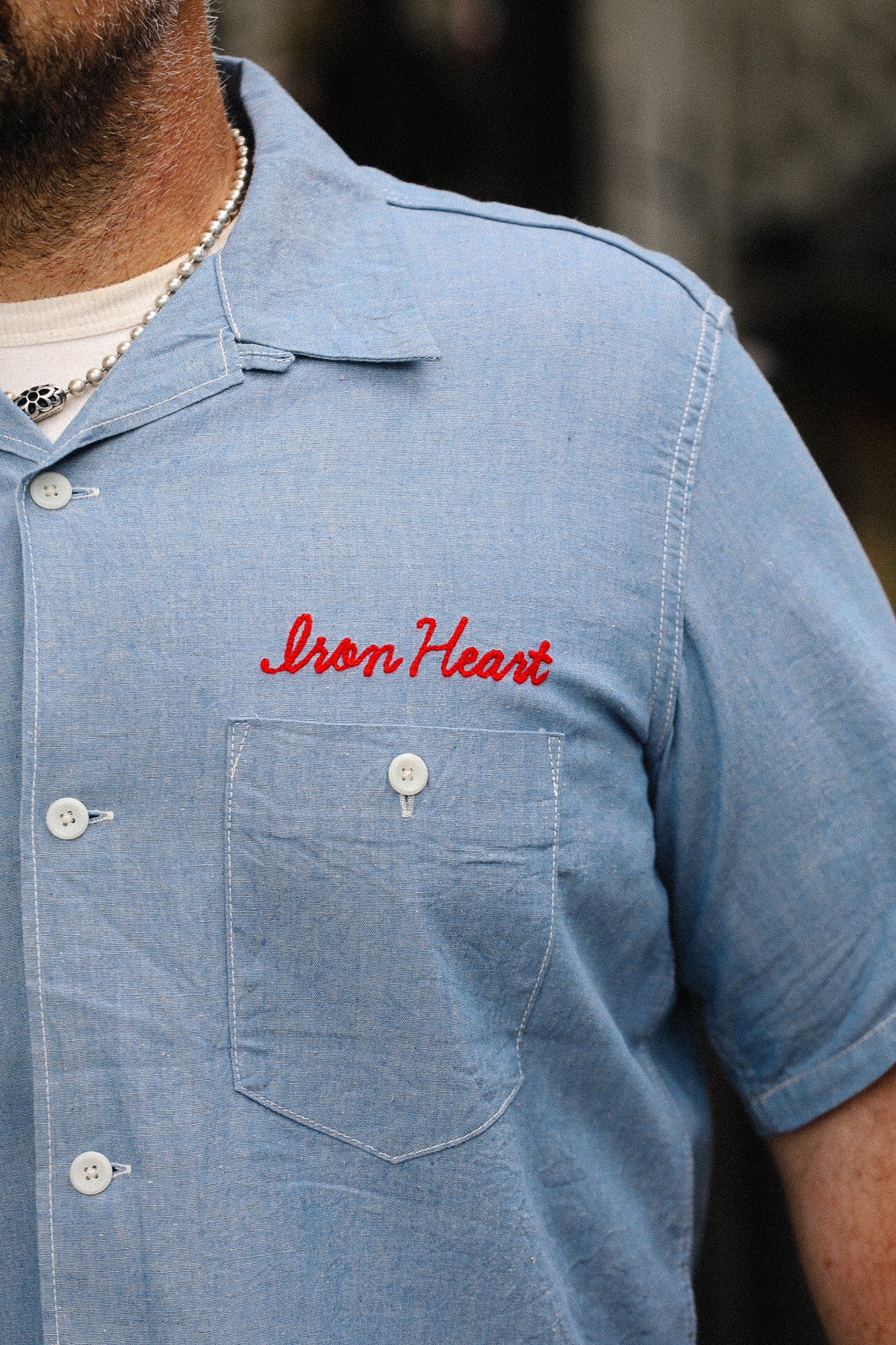 Blue shirt with 'Iron Heart' logo on a blurred background