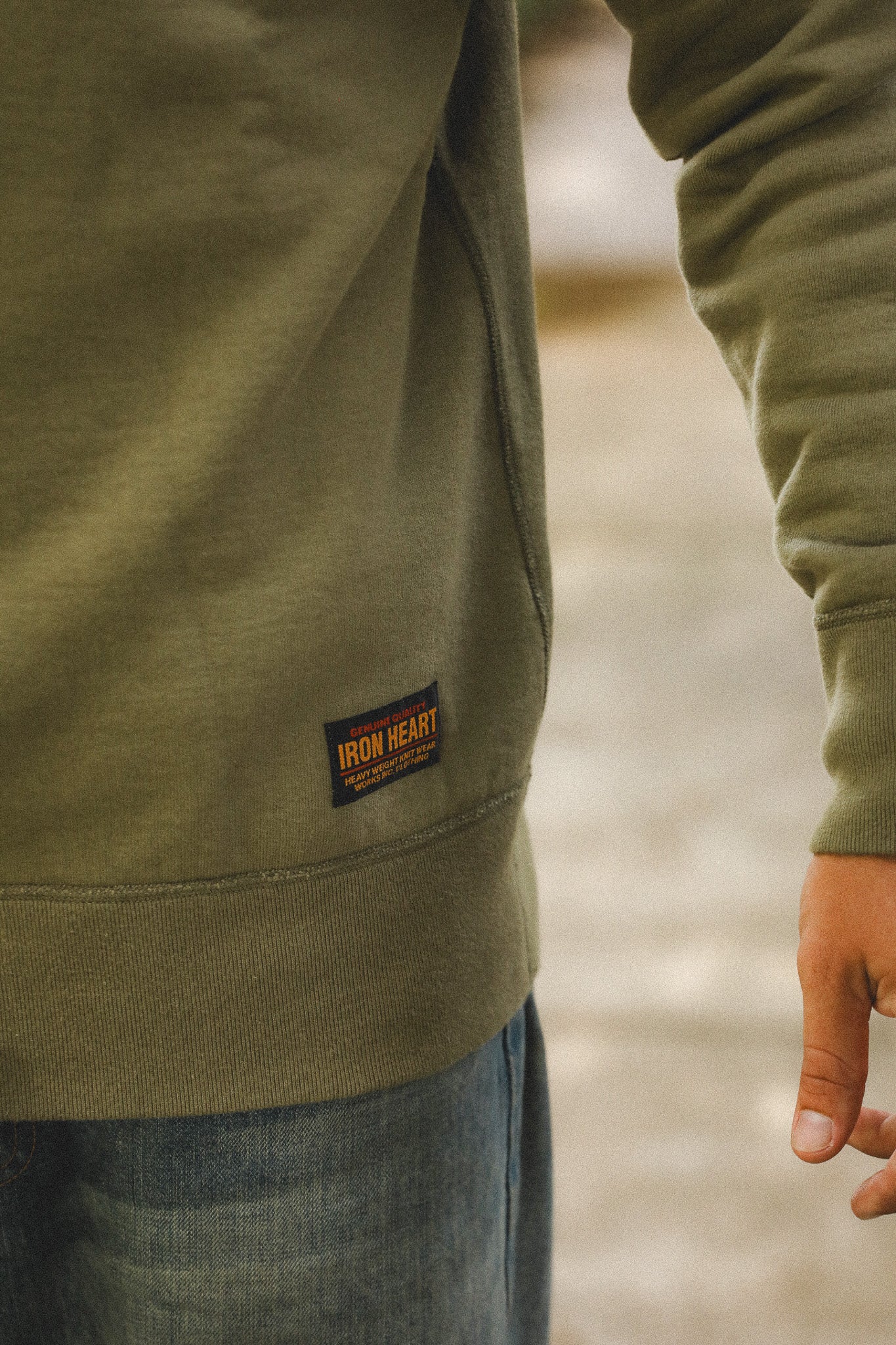 Green jacket with a brand label on a blurred natural background
