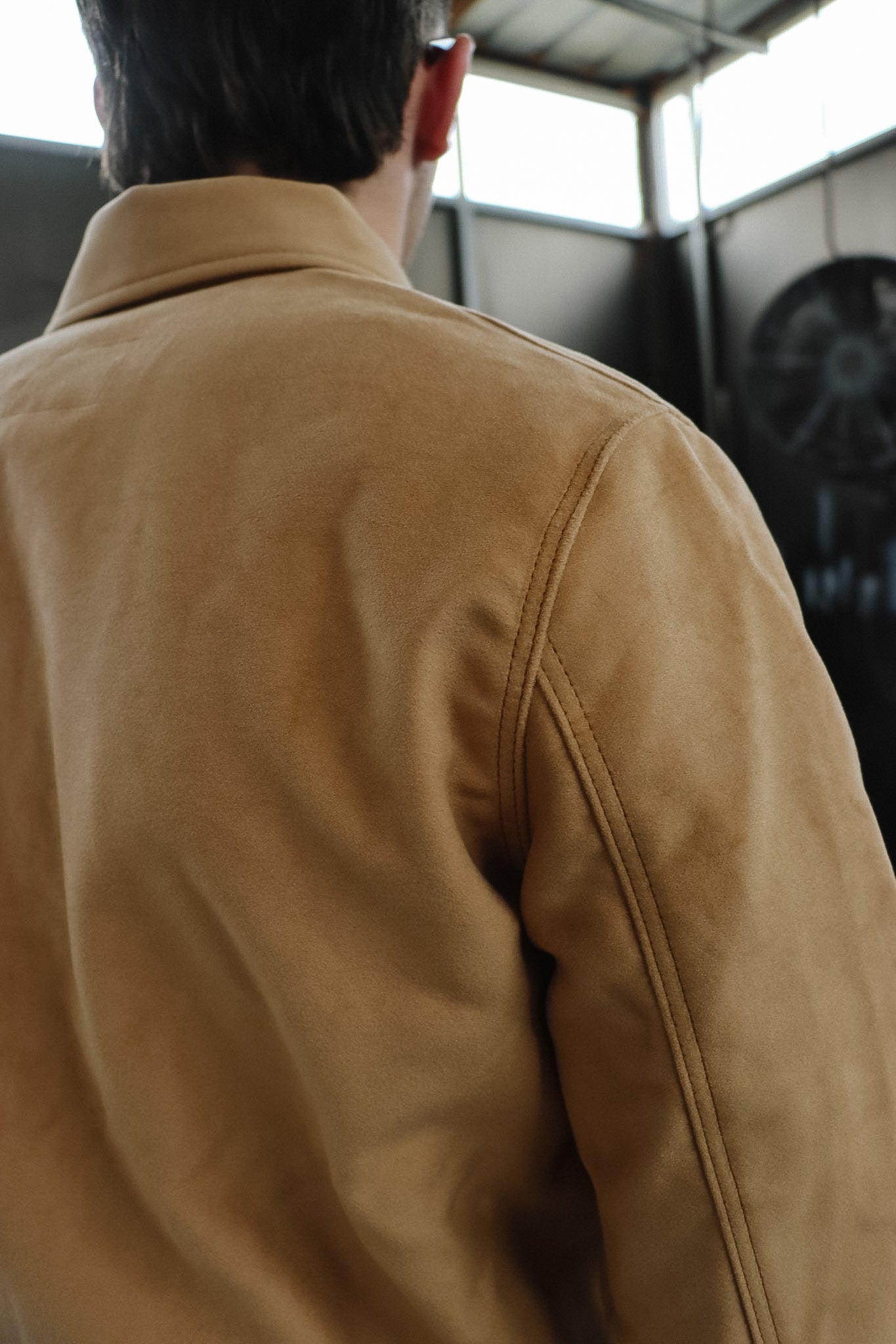 Person wearing a tan jacket with a blurred background