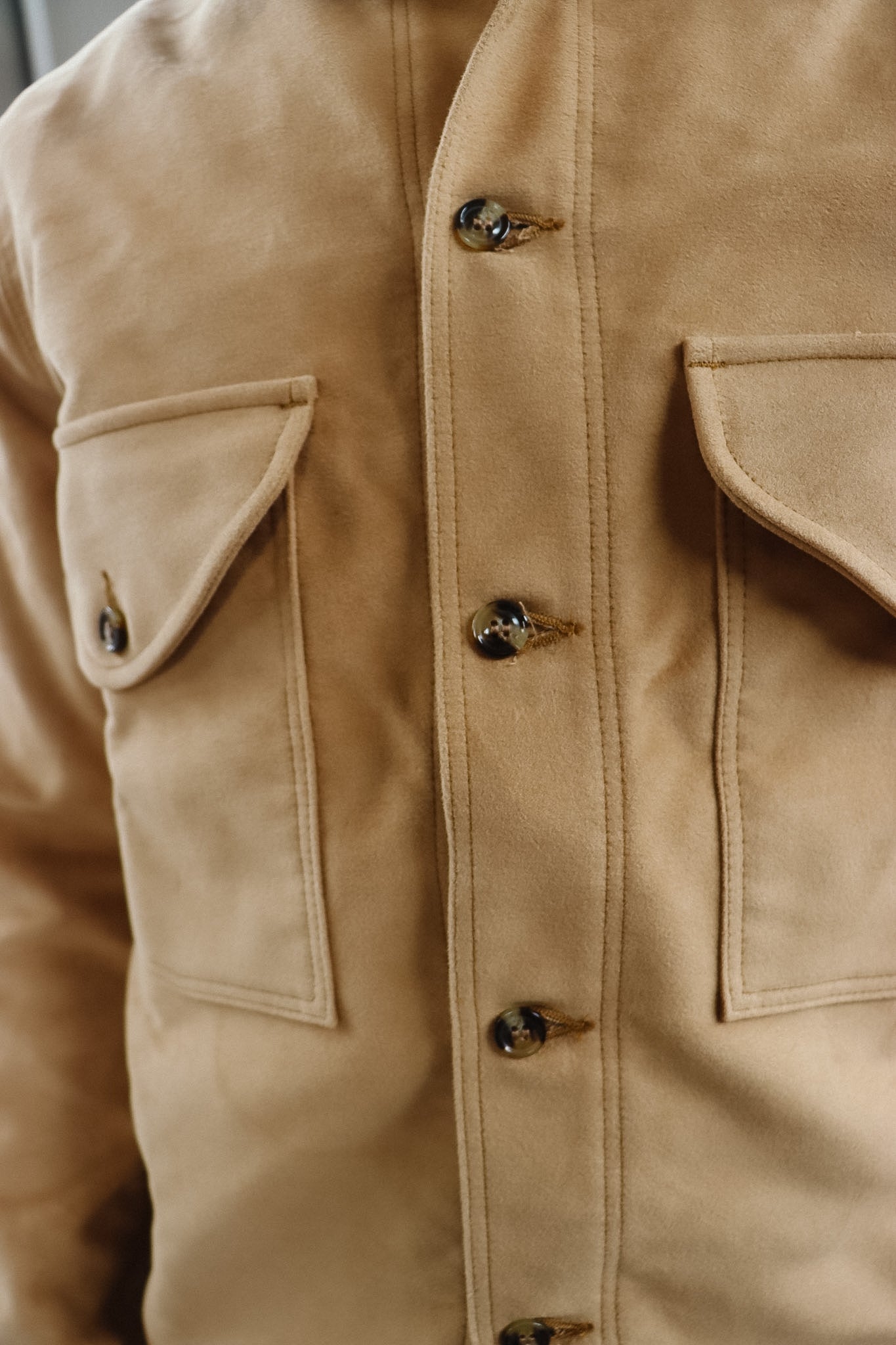 Close-up of a beige jacket with button details