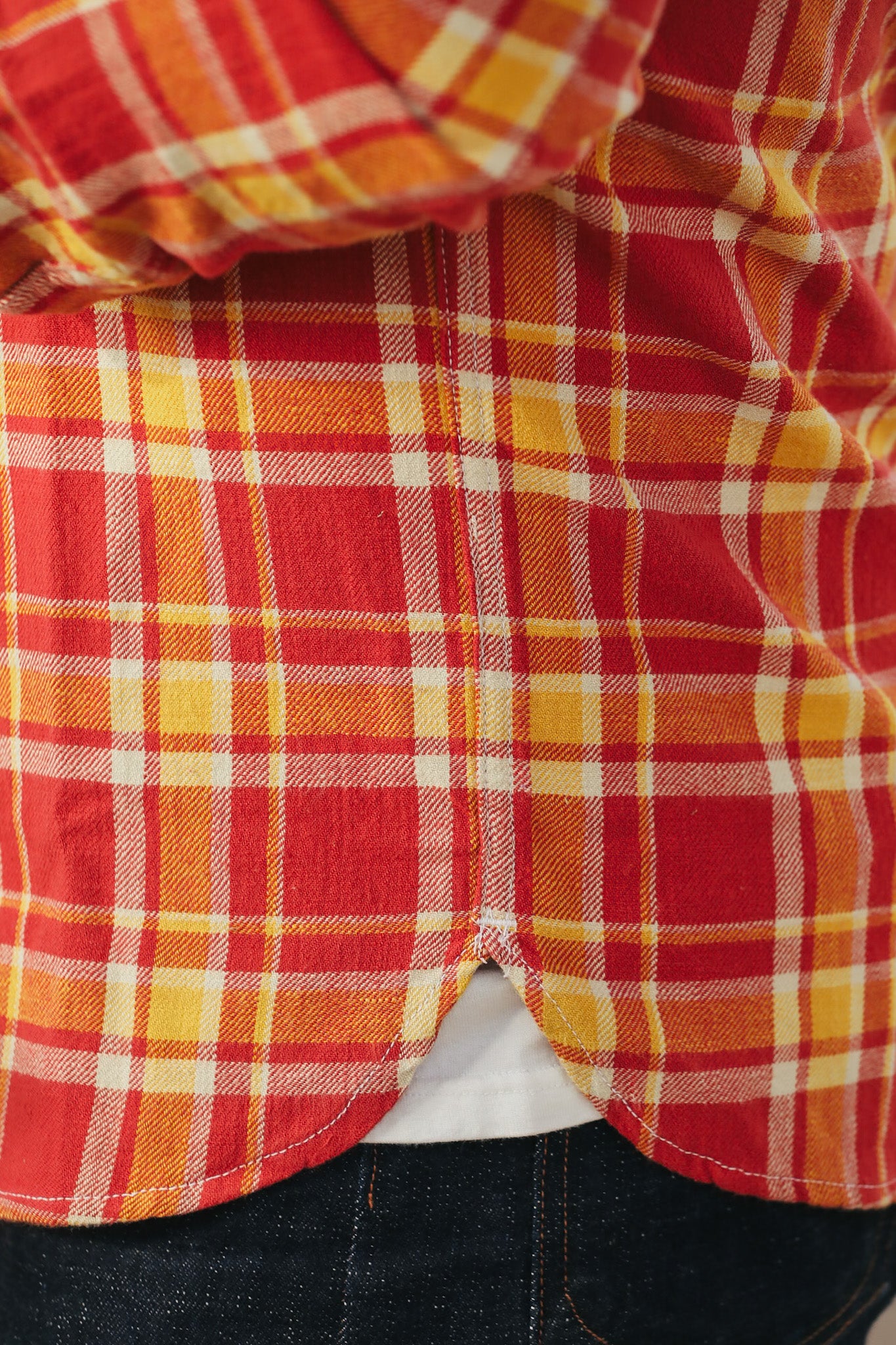 Close-up of a red and yellow plaid shirt with a blurred background
