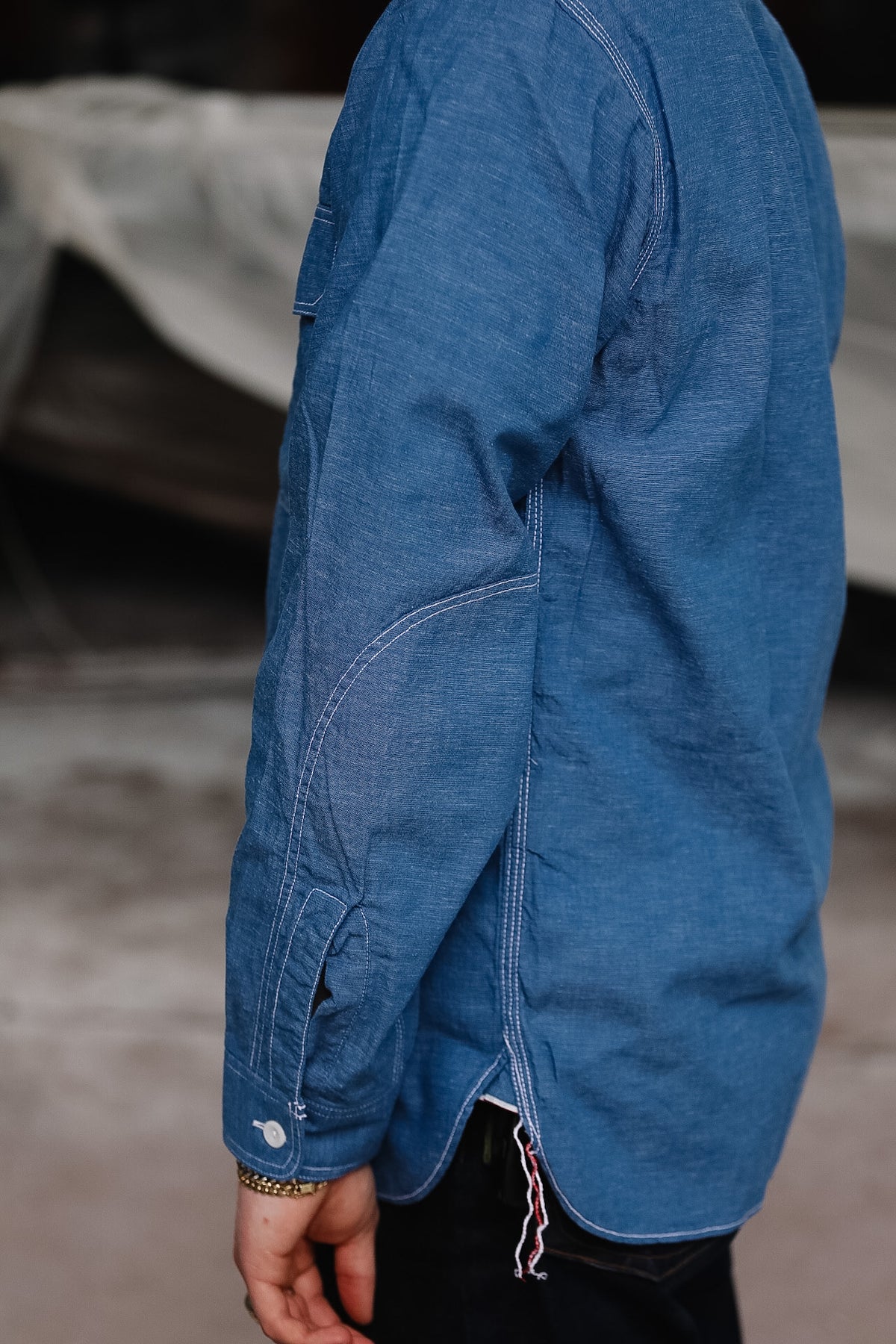 Blue denim jacket worn by a person with a blurred background