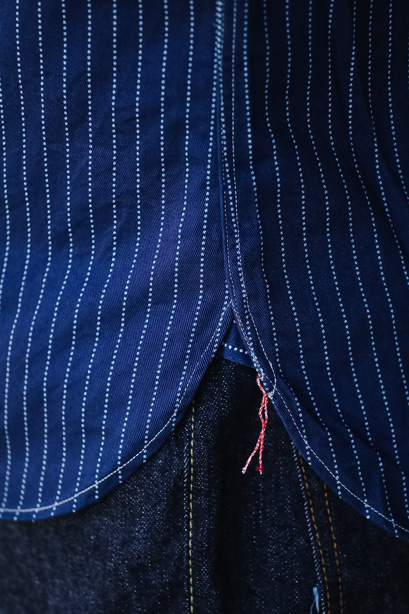 Close-up of a blue pinstripe shirt with a focus on stitching detail.