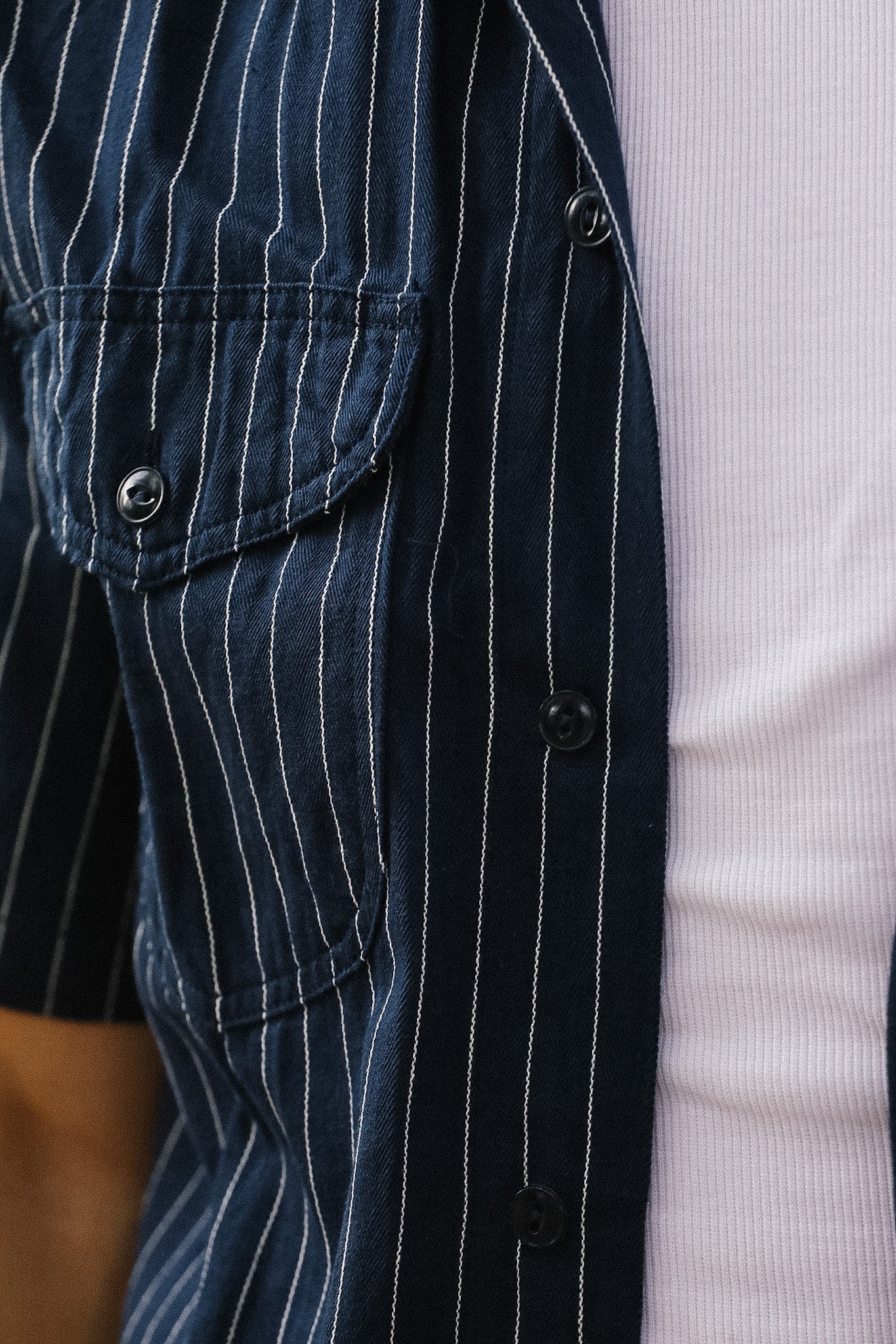 Close-up of a navy pinstripe suit jacket with a white shirt underneath.