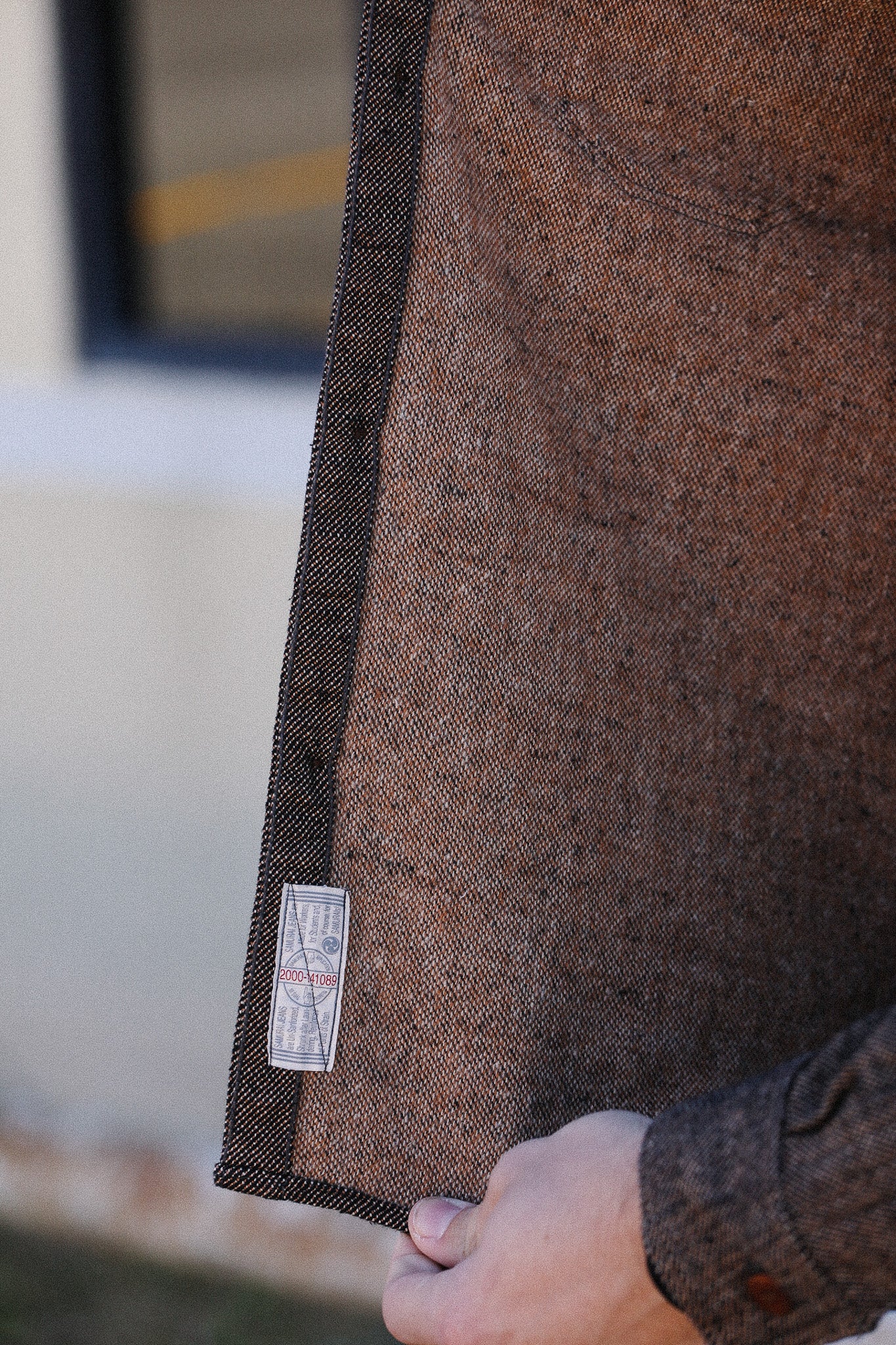 Close-up of a brown textured fabric with a label, blurred background