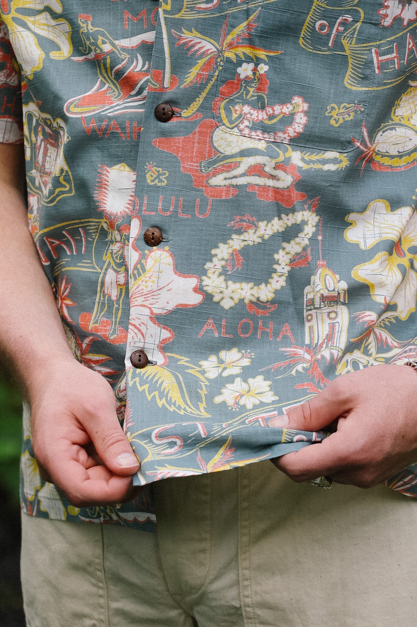 Person wearing a colorful shirt with aloha-themed design